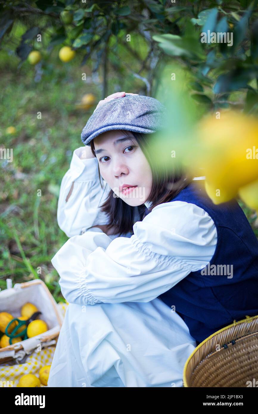 Asiatische Frau arbeiten und reisen in Zitronenfarm mit Bauernmode und Accessoires Stockfoto