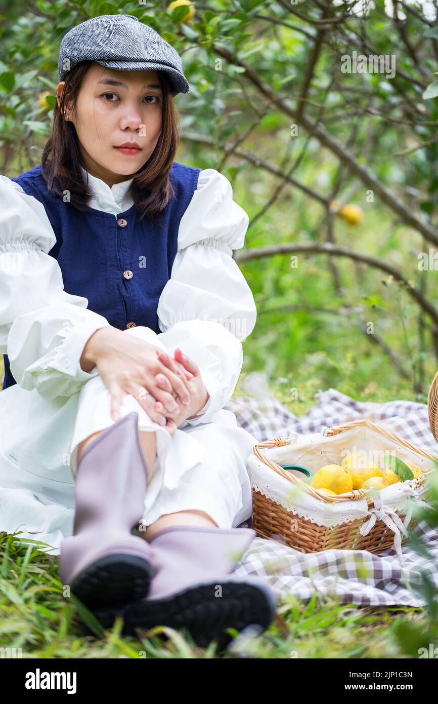 Asiatische Frau arbeiten und reisen in Zitronenfarm mit Bauernmode und Accessoires Stockfoto