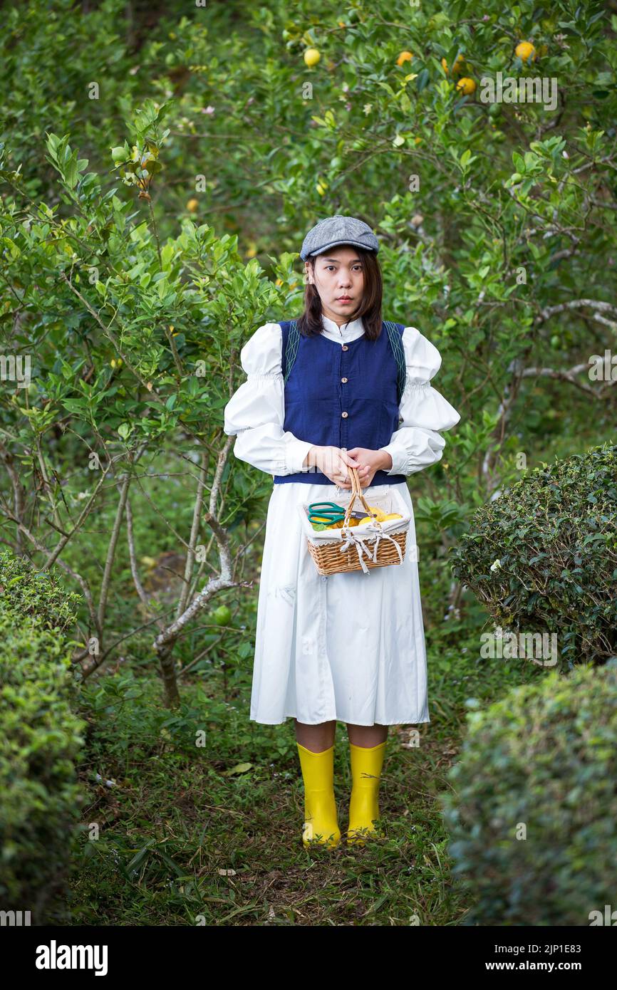 Asiatische Frau arbeiten und reisen in Zitronenfarm mit Bauernmode und Accessoires Stockfoto