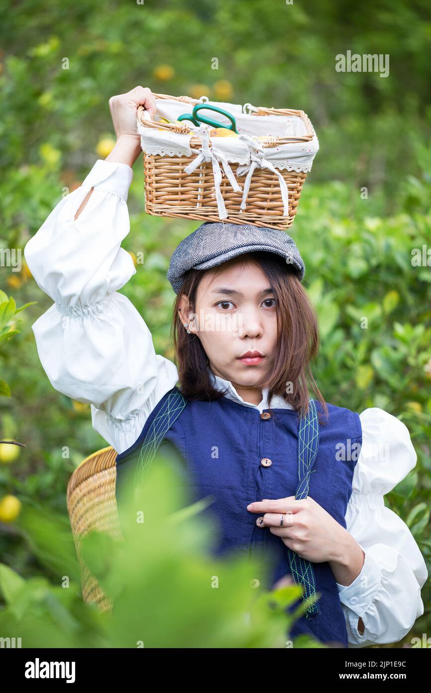 Asiatische Frau arbeiten und reisen in Zitronenfarm mit Bauernmode und Accessoires Stockfoto