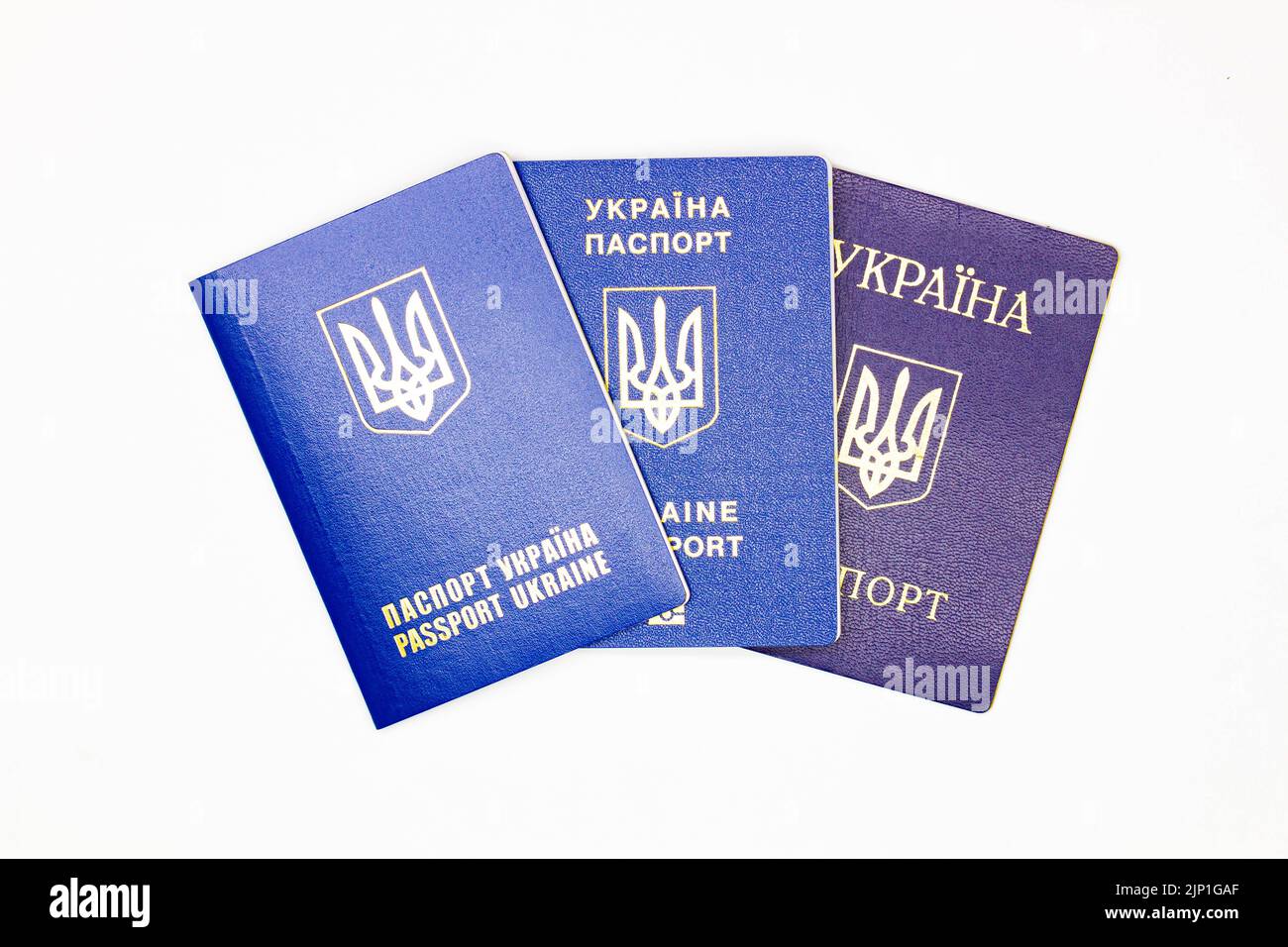 Pass der Ukraine. Drei Deckblatt des Staatsdokuments des ausländischen ukrainischen Passes mit dem Wappen der Ukraine in blau auf weißem Hintergrund Stockfoto