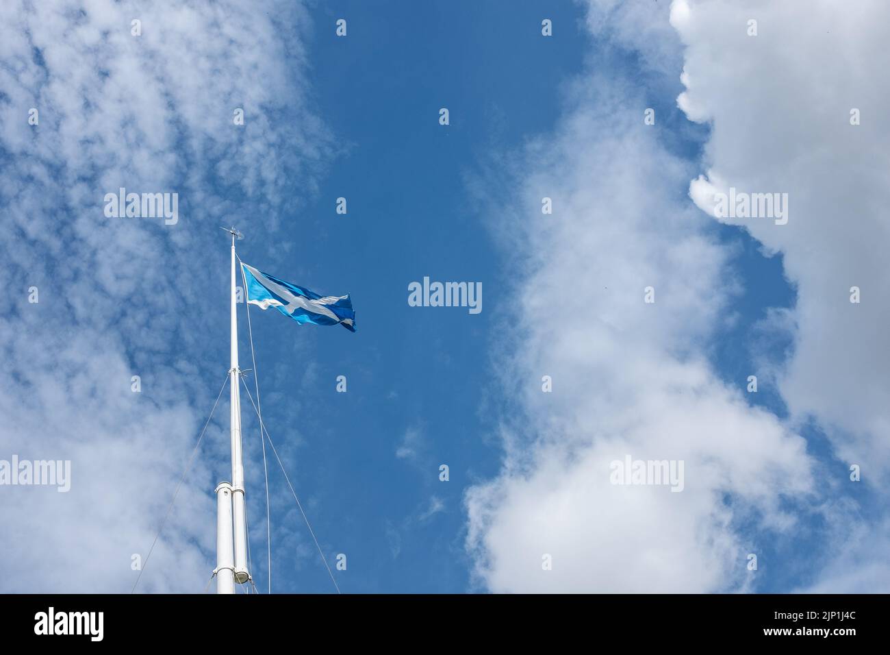 Saint Andrew's Cross, Saltire, die schottische Flagge flattert auf dem Fahnenmast vor dem Hintergrund des blauen Himmels und der hellen Wolken bei Bannockburn, Schauplatz der Schlacht. Stockfoto