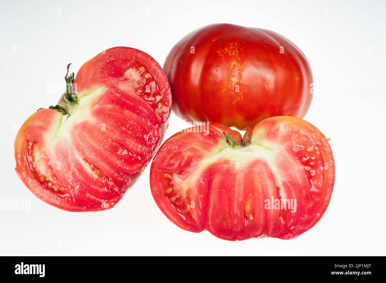 Zwei Tomaten - eine große rote reife Tomate, halbiert Stockfoto