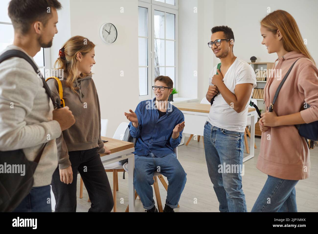 Lächelnde multiethnische Studenten haben Spaß, in der Pause zu kommunizieren Stockfoto