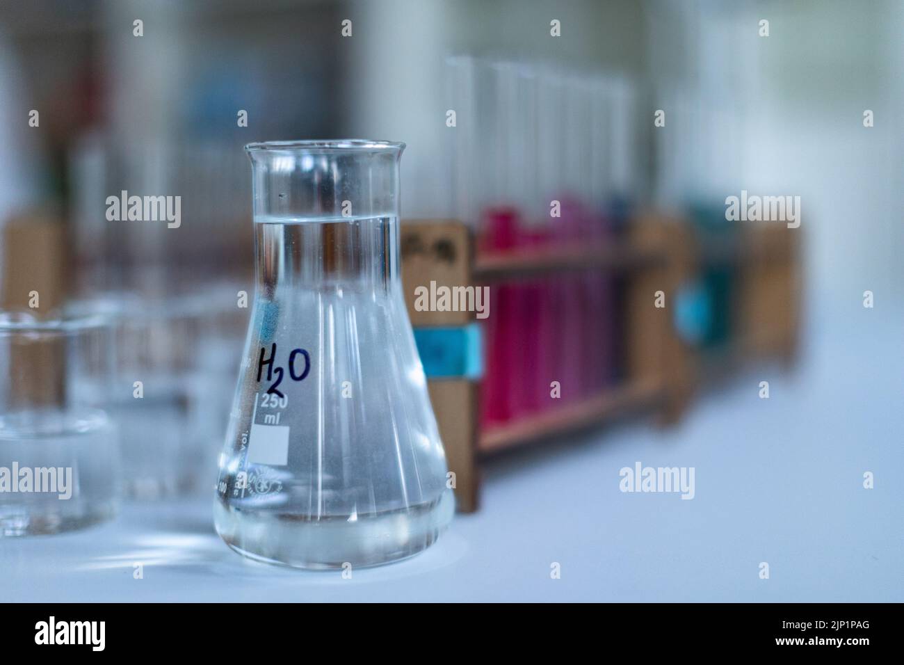 Nahaufnahme von Messbechern und Reagenzglas im Chemielabor. Stockfoto