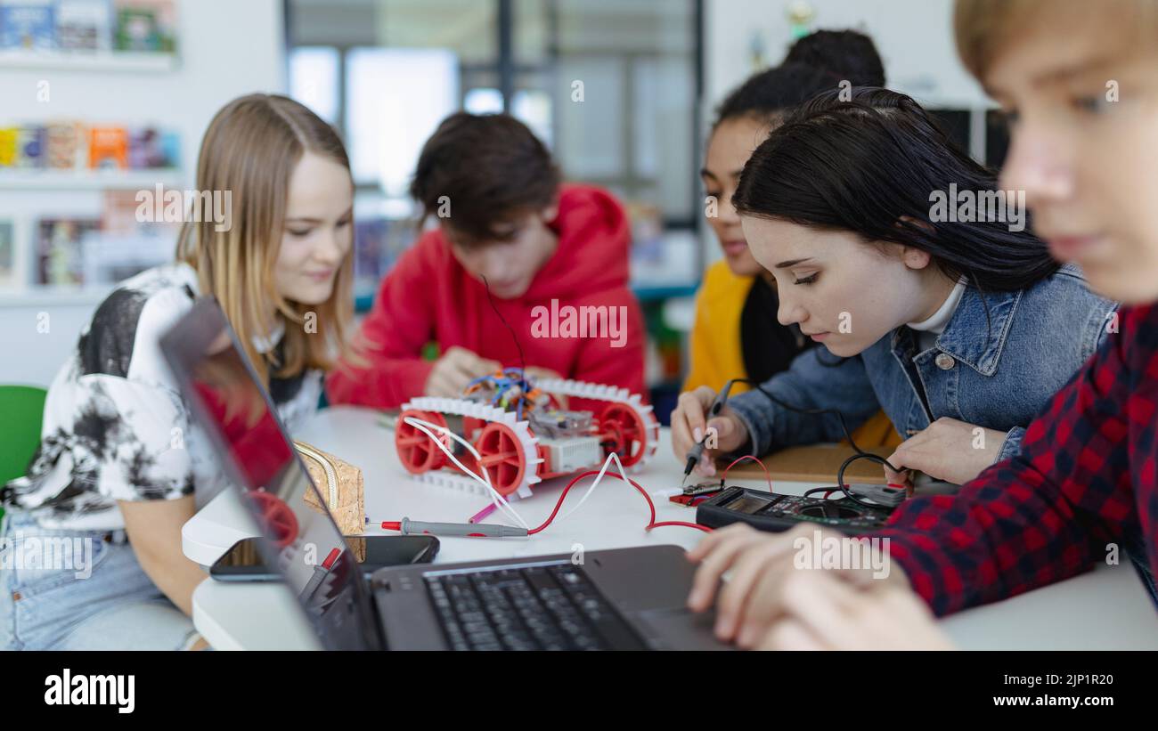 Eine Gruppe von Schülern, die elektrische Spielzeuge und Roboter im Roboterunterricht bauen und programmieren Stockfoto