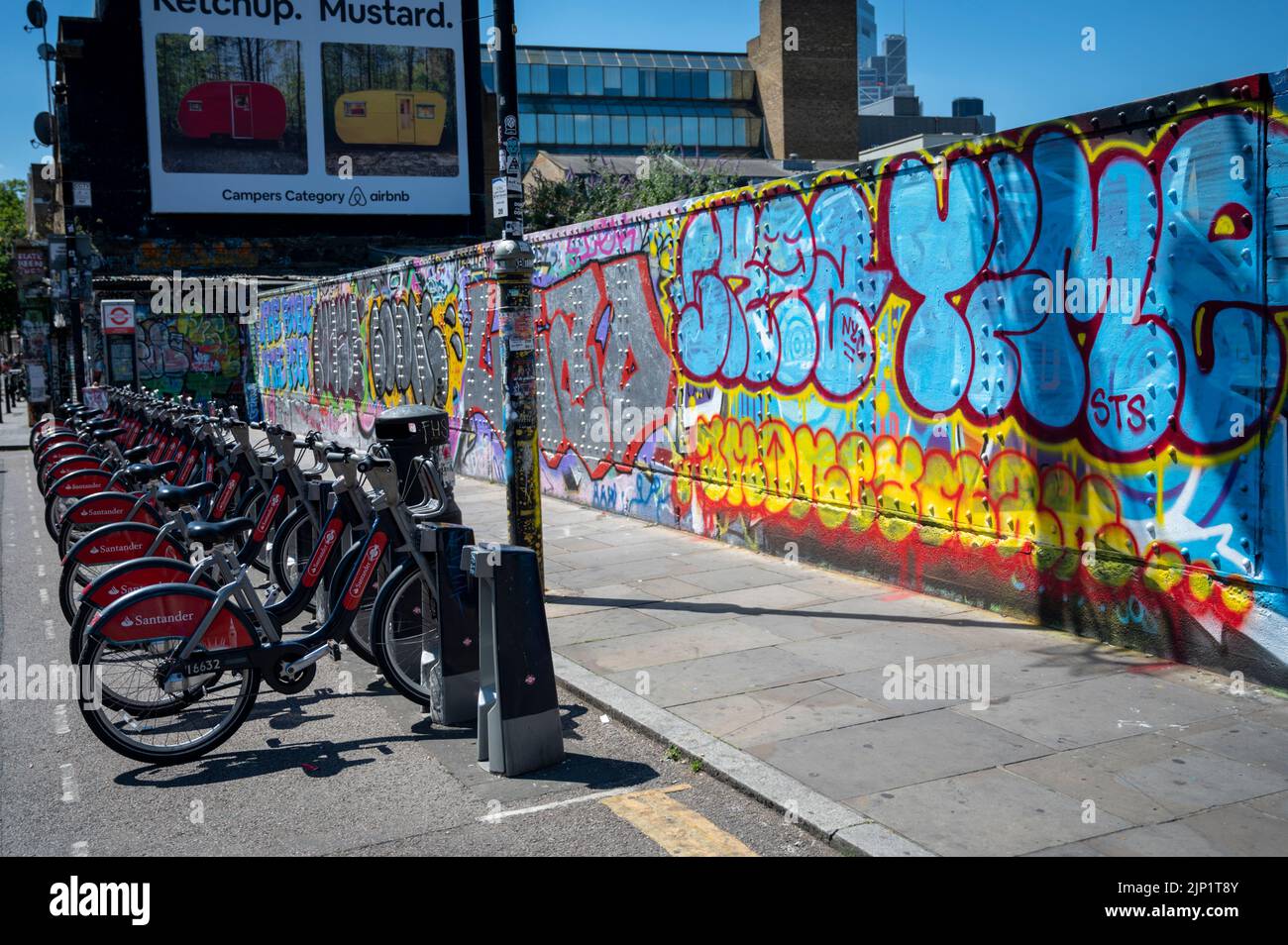 Santander mietet Fahrräder, die in einem Fahrradständer in Brick Lane London, Großbritannien, geparkt sind Stockfoto