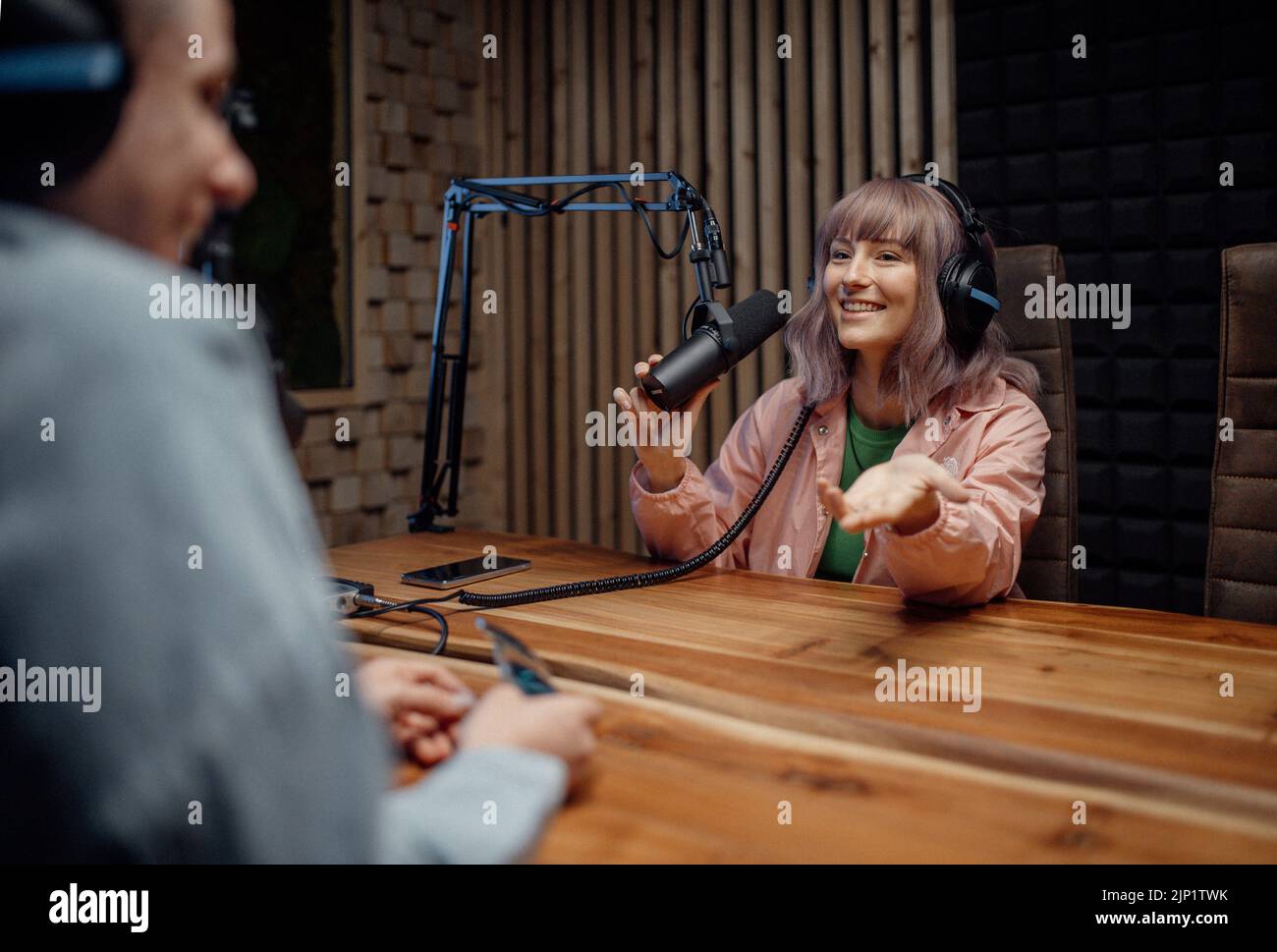 Porträt einer Sprecherin im Radio, die während der Moderation einer Live-Show im Mikrofon spricht Stockfoto