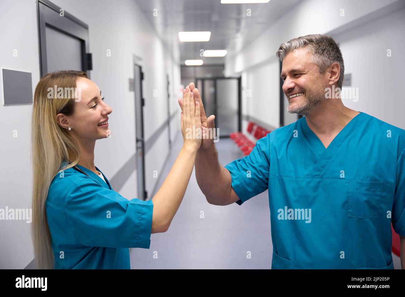 Zwei smilling und glückliche Ärzte geben einander hohe fünf Stockfoto