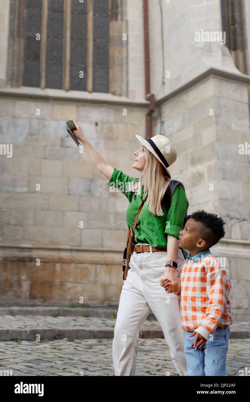 Mutter und ihr multirassischer Sohn reisen zusammen und gehen in die Altstadt. Stockfoto