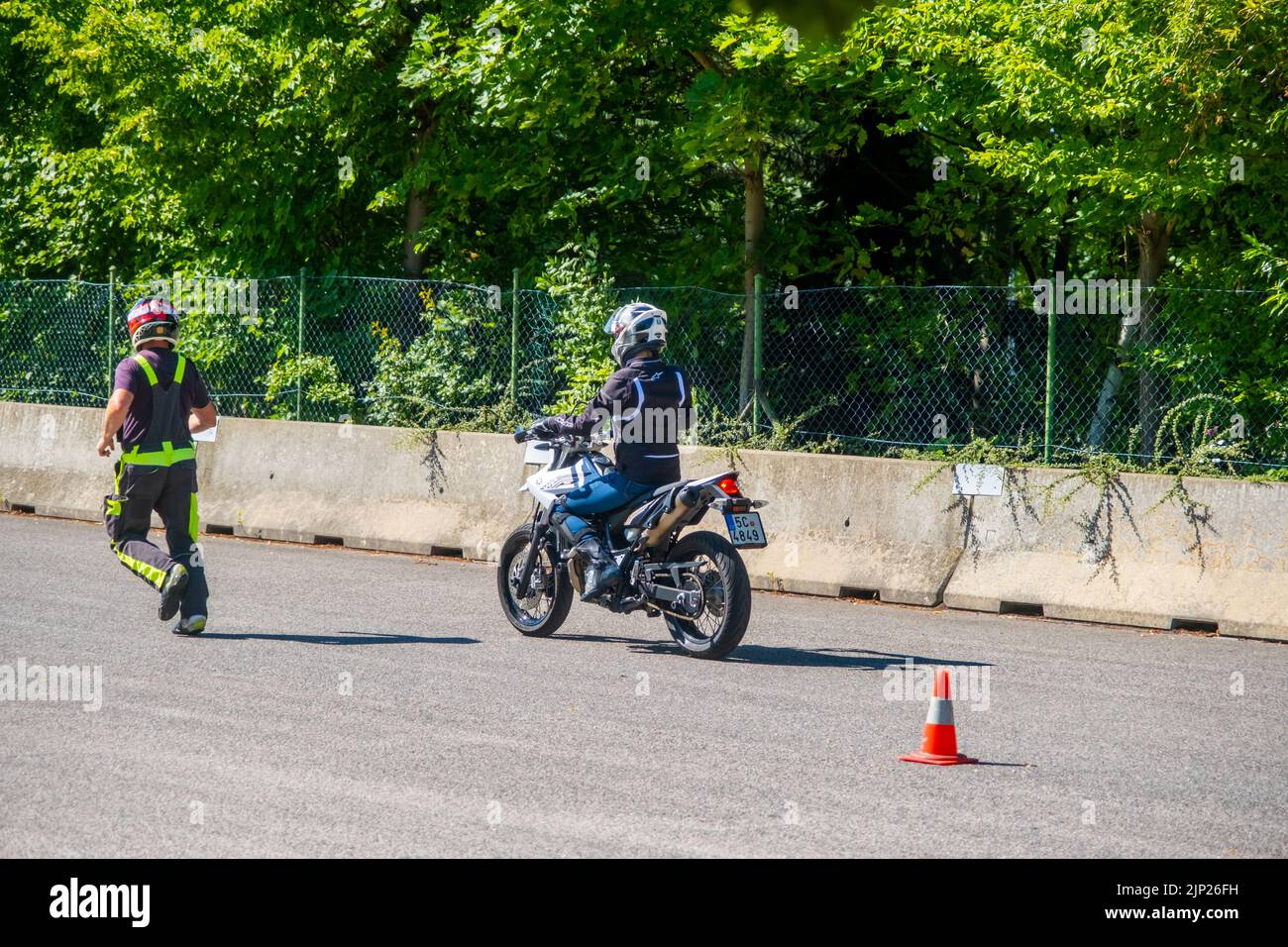 Prag, Tschechische Republik - 12. Juli 2022: Männlicher Instruktor kontrolliert den L-Fahrer, während sie im Geschicklichkeitstraining Motordrome Fahrrad fährt Stockfoto