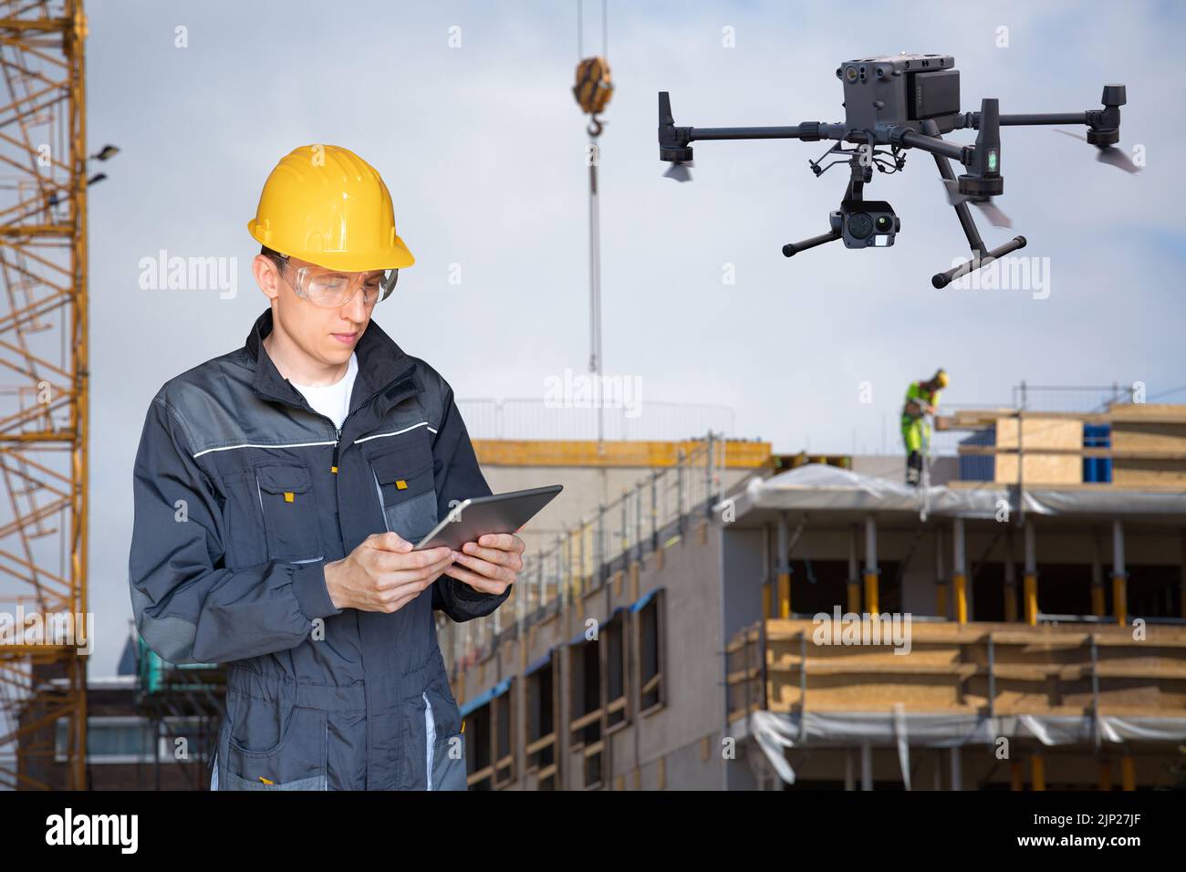 Ingenieur mit digitalem Tablet steuert Drohne auf einer Baustelle Stockfoto