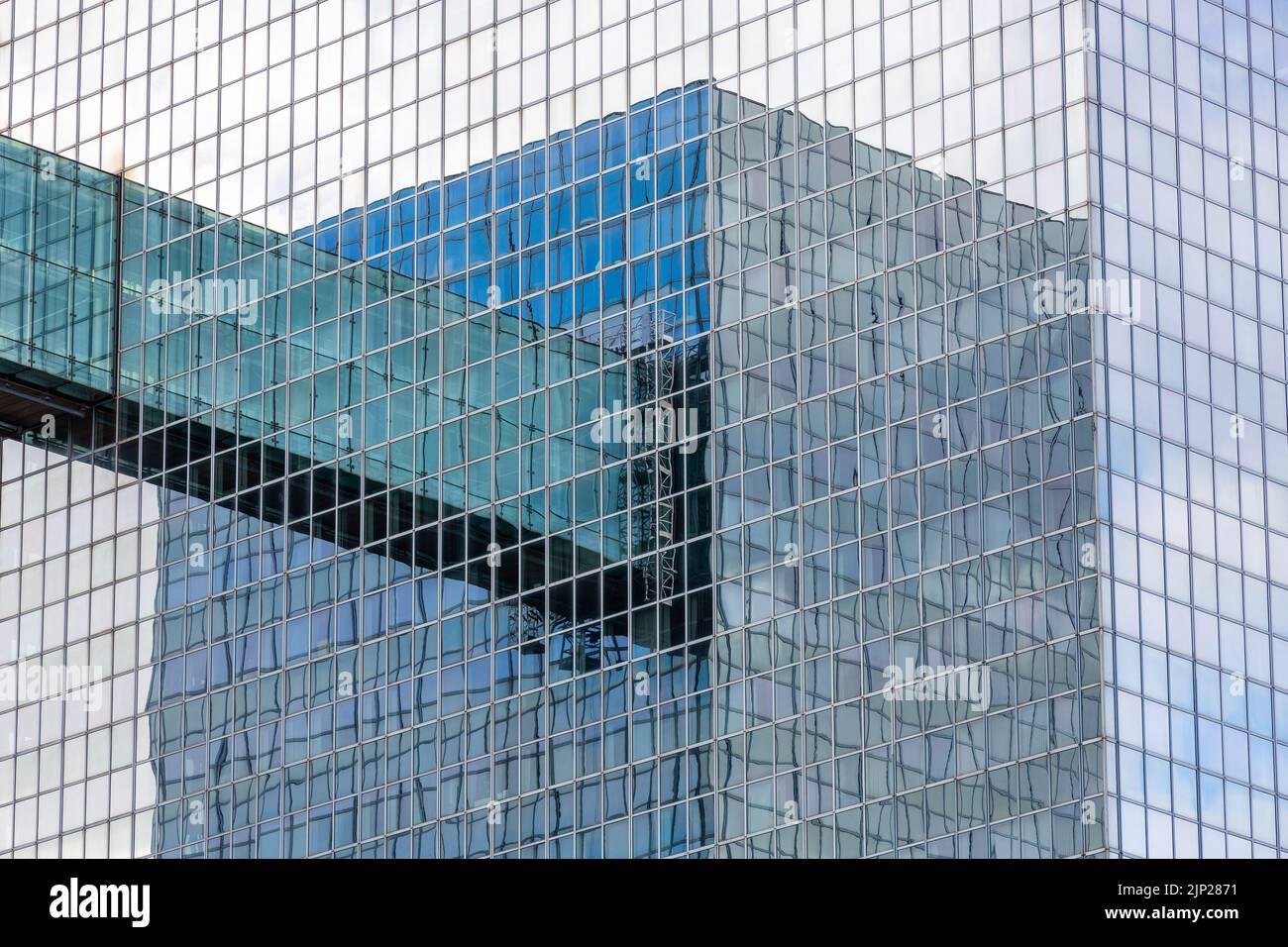 Wechselseitig reflektierte Bilder von zwei Glastürmen, die durch einen Gang miteinander verbunden sind. Stockfoto