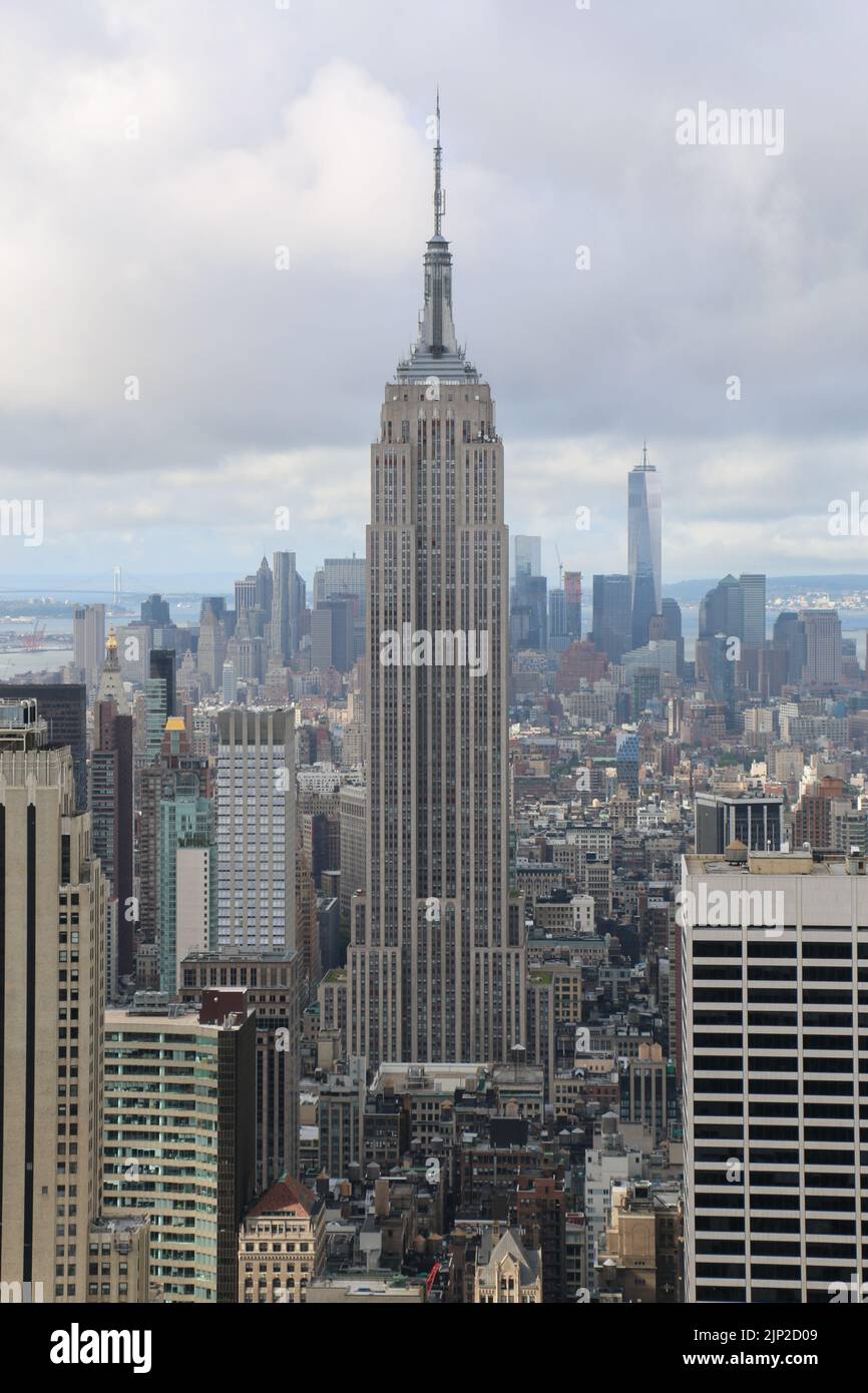 Eine vertikale Aufnahme des Empire State Building von der Spitze eines Wolkenkratzers in New York City, USA Stockfoto