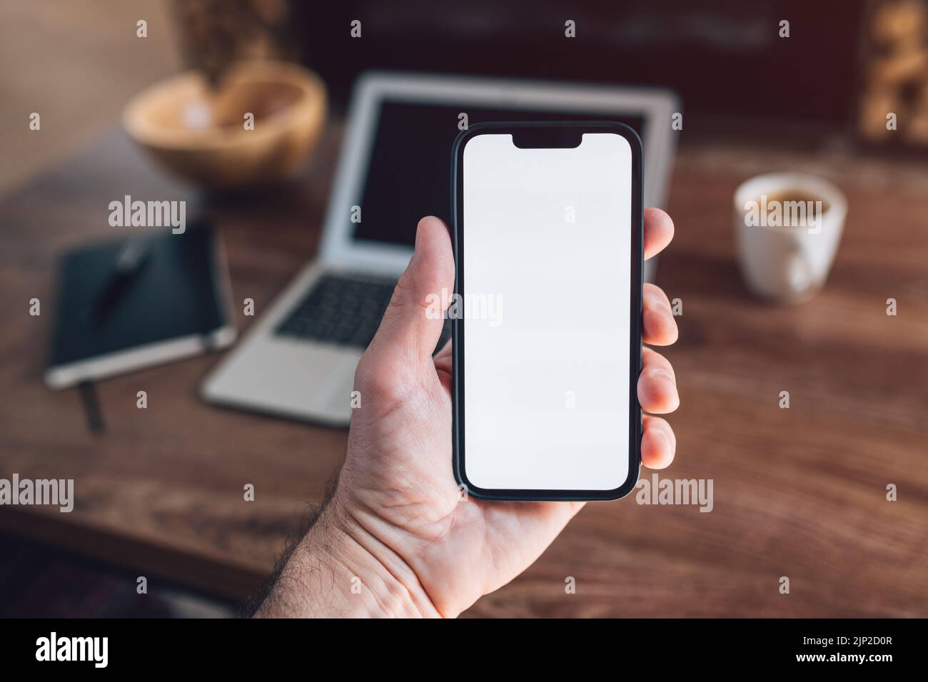 Smartphone-Mockup, Internet der Dinge und Smart-Home-Konzept, Mann mit Mobiltelefon. Nahaufnahme der Handhaltevorrichtung mit leerem Bildschirm im Home Interi Stockfoto