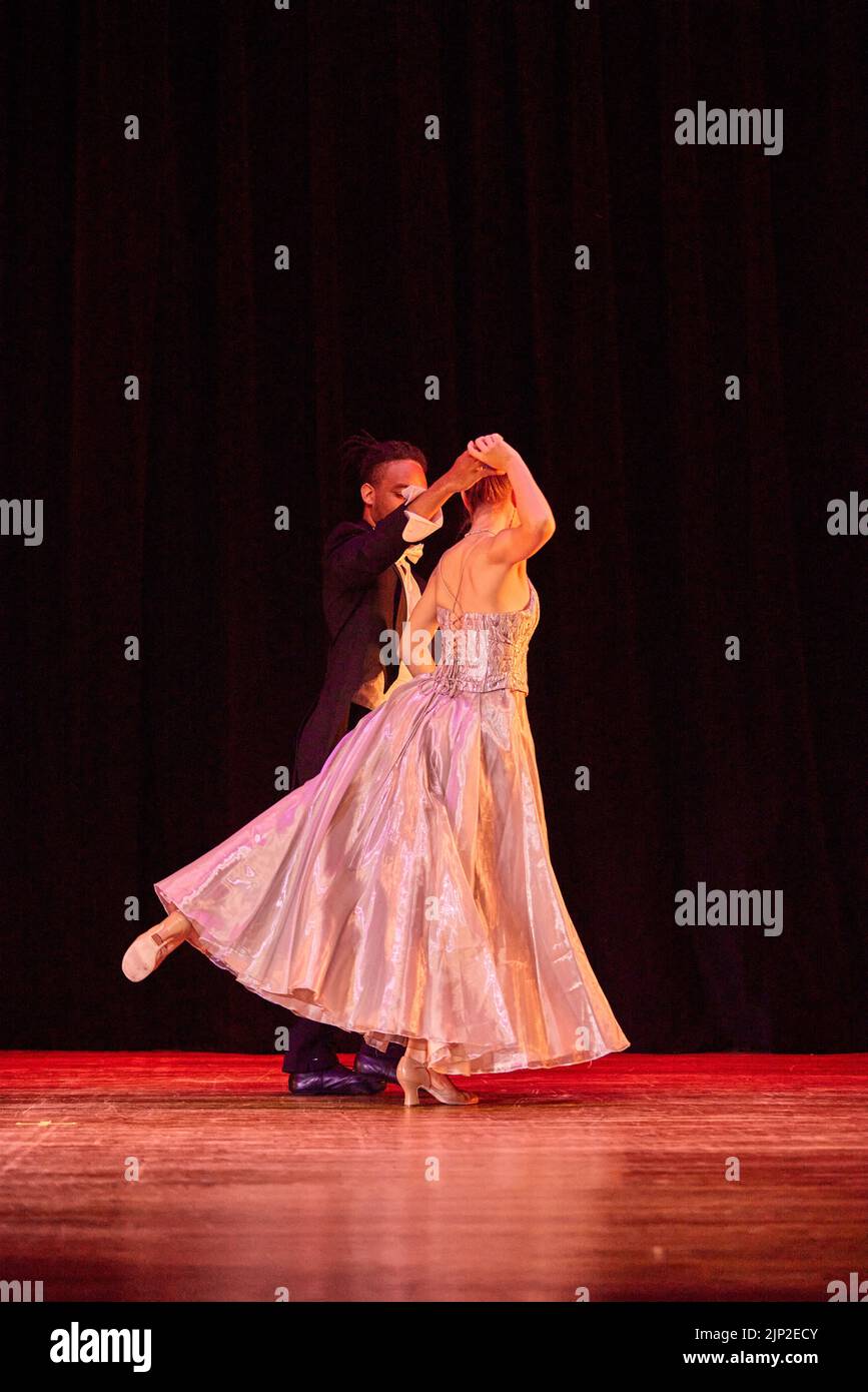 Eine vertikale Aufnahme von ein paar Balletttänzern in klassischer Kleidung während eines Rezents auf einer Bühne Stockfoto