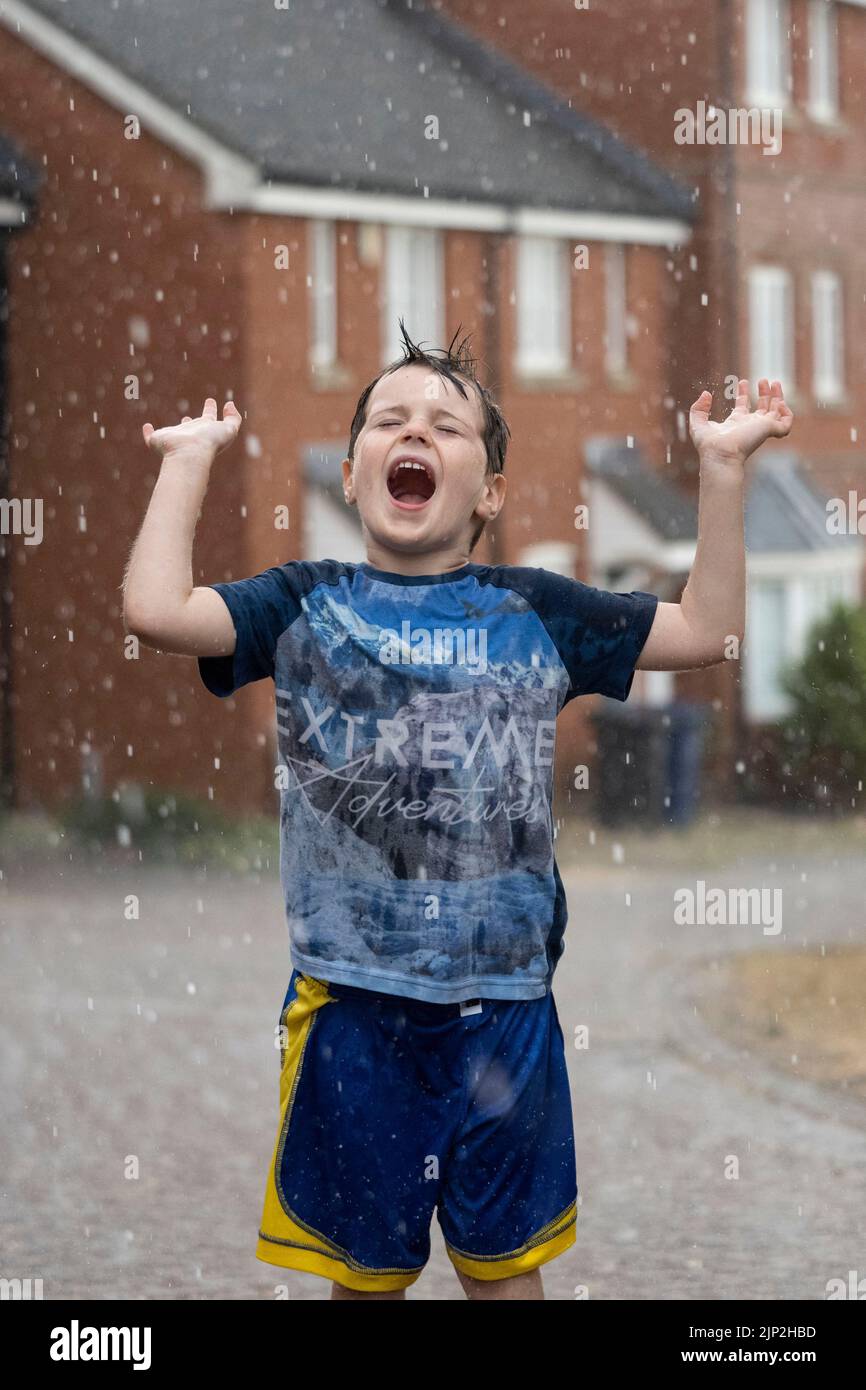 Haverhill, Suffolk, Großbritannien 15.. August 2022. Albert Mitchell, 5 Jahre alt, genießt den sintflutartigen Regen in Haverhill, Suffolk. Kredit: Headlinephoto/Alamy Live Nachrichten. Stockfoto