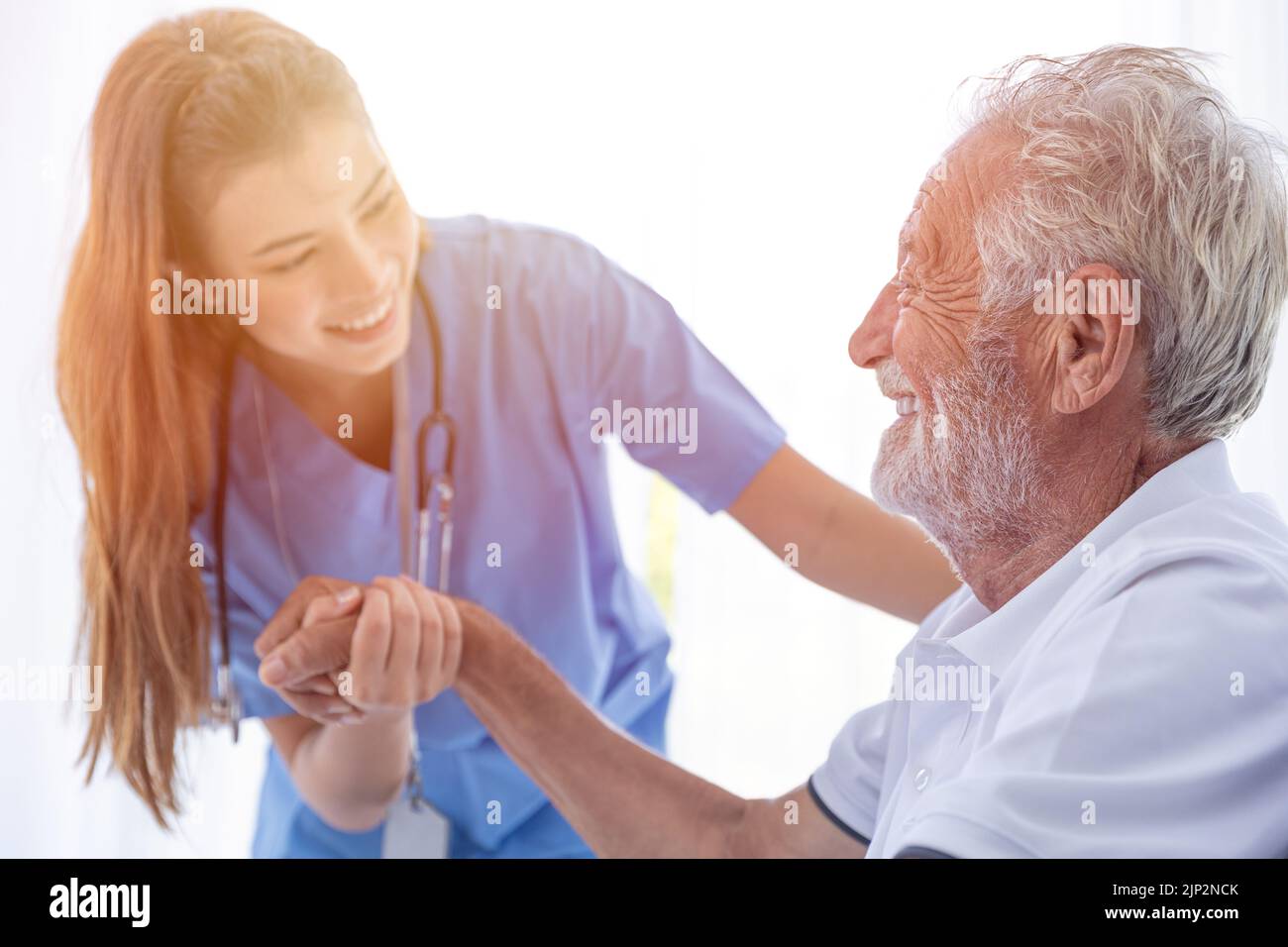 Krankenschwester Medizinisches Personal Mitarbeiter Support Service Gesundheitswesen Ältester Mann in der häuslichen Pflege glückliches Lächeln, das zusammen schaut. Stockfoto
