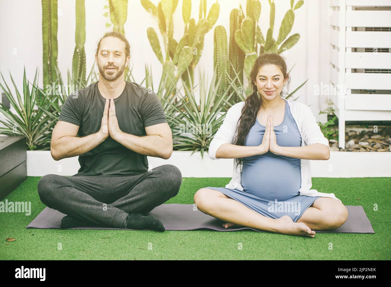 Schwangeren Mutter mit Ehemann Praxis Meditation Yoga für Ruhe und Entspannung gut für die Gesundheit des Babys Stockfoto