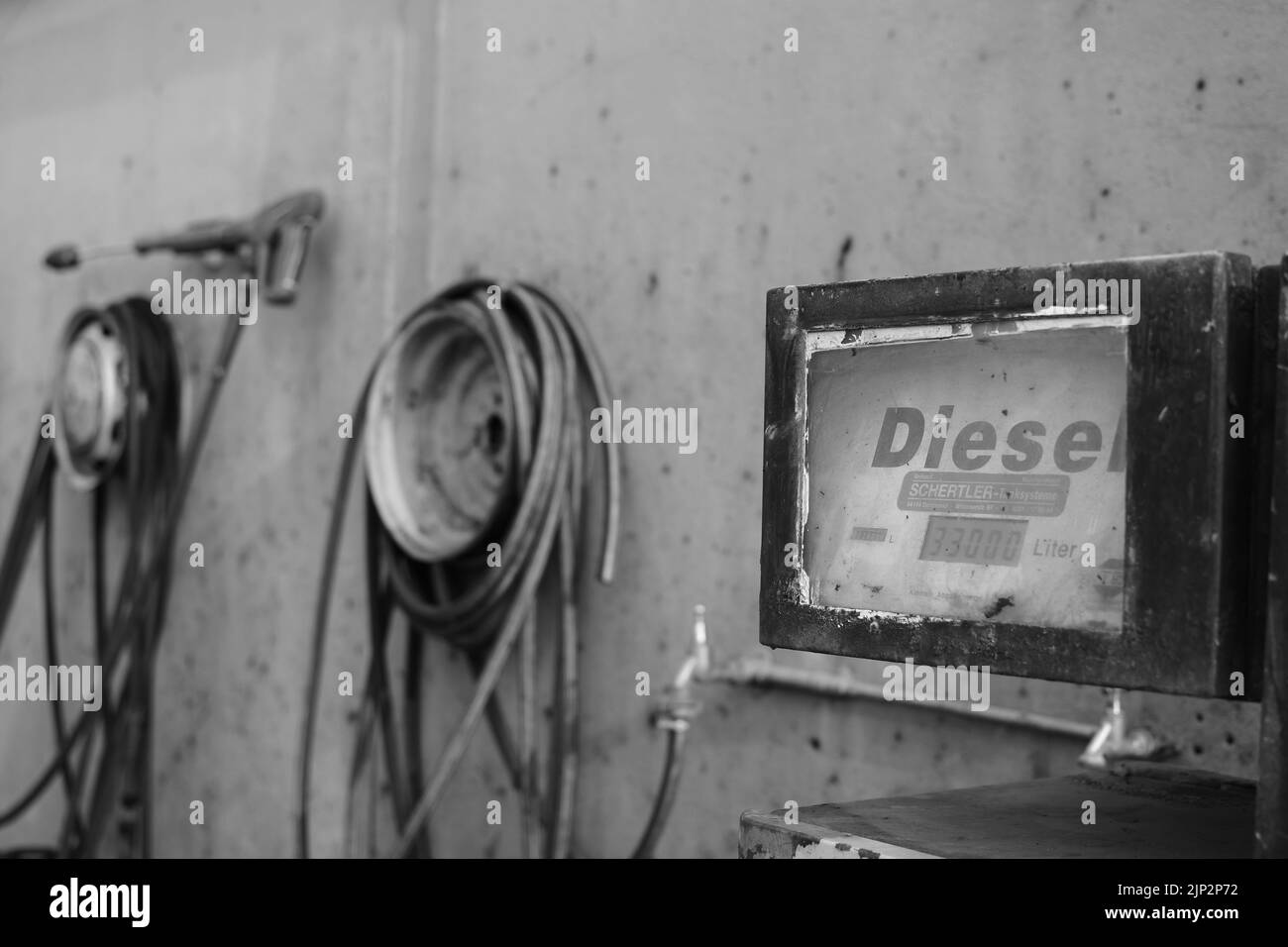 Eine Graustufe einer alten Retro-Tankstelle mit Dieselpumpe Stockfoto