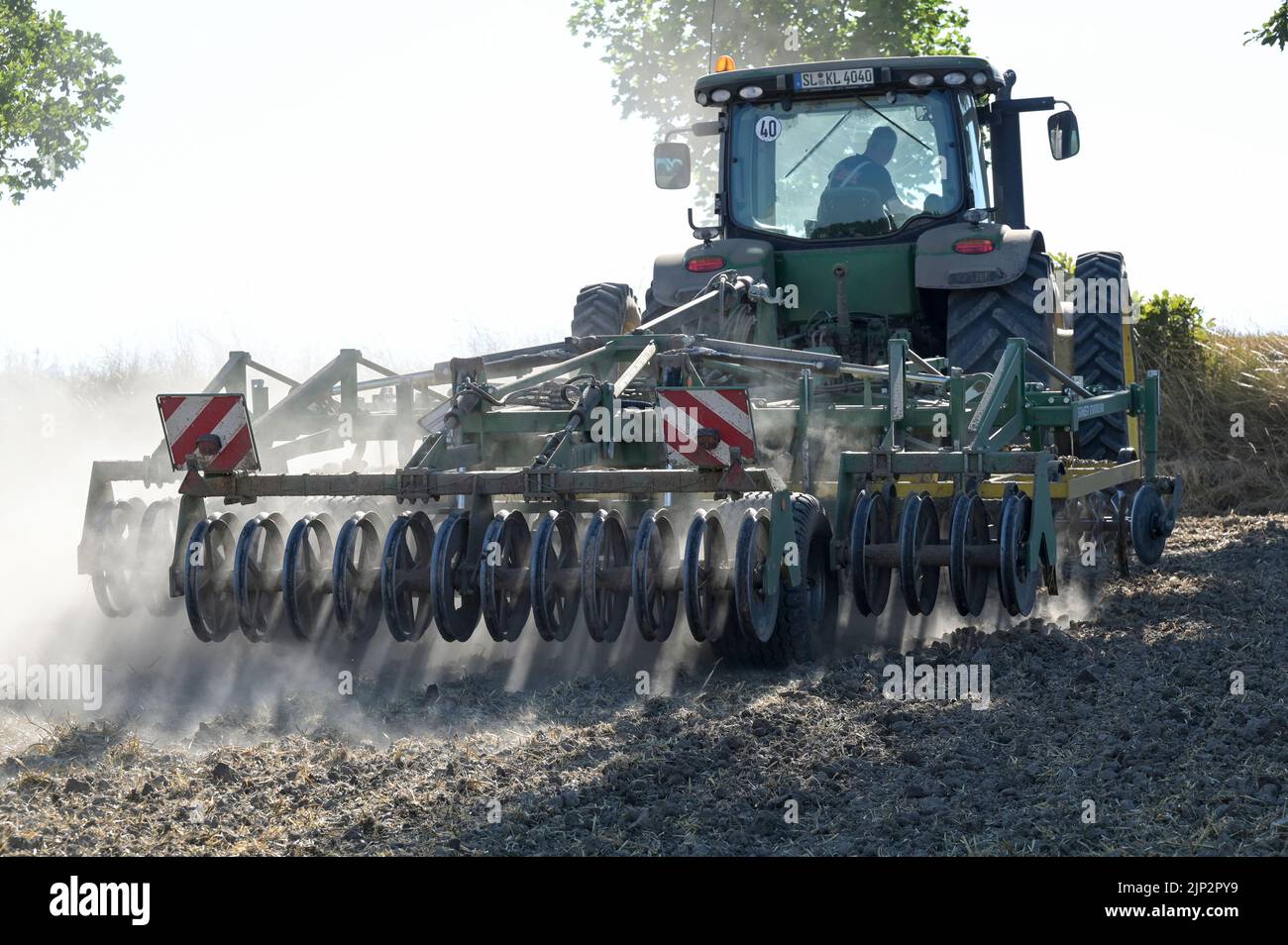 Deutschland, Landwirtschaft, Pflugloser Anbau / DEUTSCHLAND, Schleswig Holstein, Holtsee, Harzhof praktiziert seit 30 Jahren pfluglosen Ackerbau, Flachgrubber Kerner Stratos 500 am John Deere Traktor Stockfoto