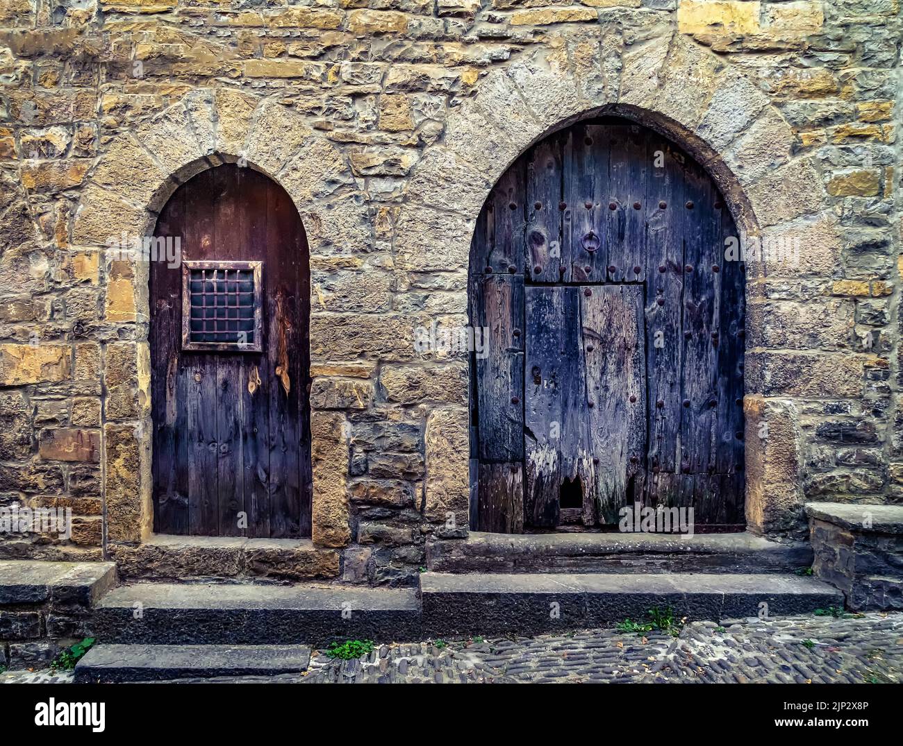 Straße einer alten mittelalterlichen Stadt mit Steinhäusern und Kopfsteinpflasterböden, Straßenlampen und einer Atmosphäre vergangener Zeiten. Ainsa, Spanien. Stockfoto
