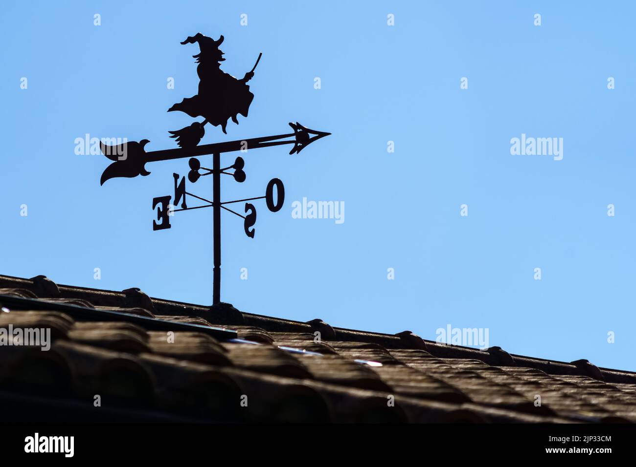 Flügel auf dem Dach des Hauses im Freien mit Hexe und Pfeil, die Richtung des Windes zeigen. Spanien. Wettervane. Stockfoto