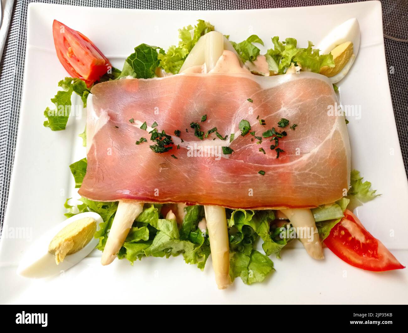 Une entrée dans un Restaurant français, Salade, oeuf et jambon de bayonne Stockfoto