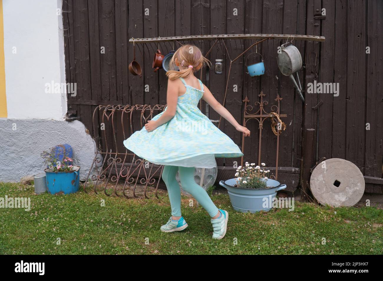 Mädchen tanzt vor der Scheune rotierendes Kleid Stockfoto