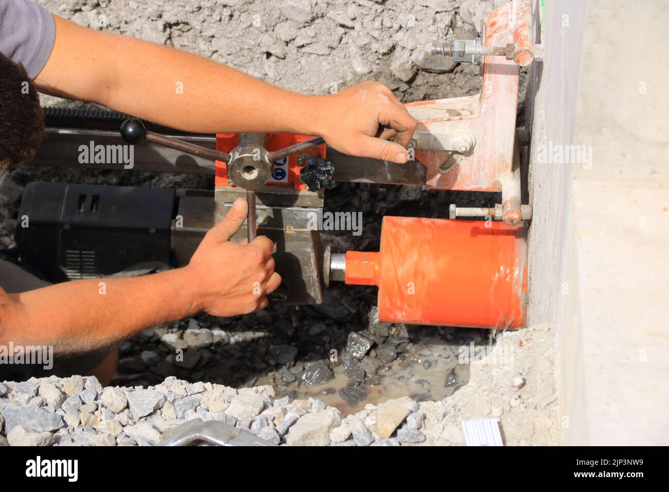 Arbeiter bohrt ein Kernloch in eine Hauswand Stockfoto
