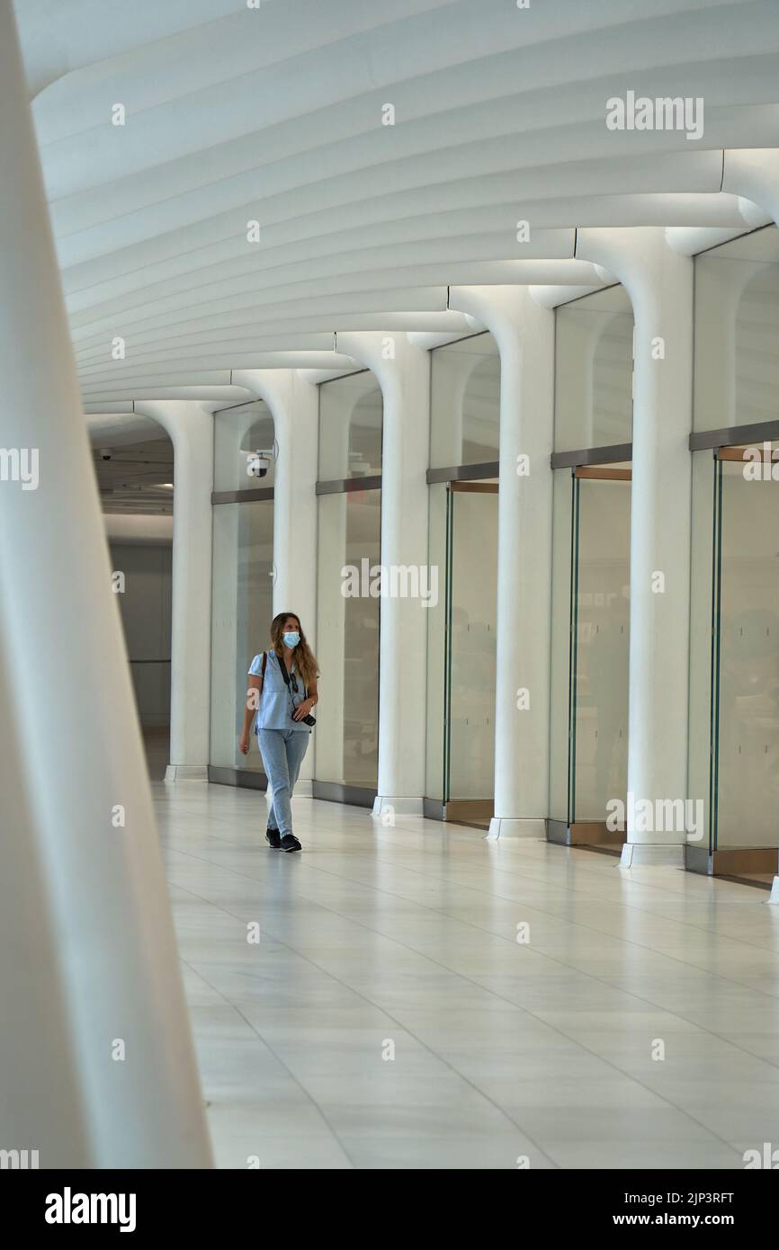 Eine Frau, die im Gebäude des „Bizulus“ in Manhattan spazierend ist Stockfoto