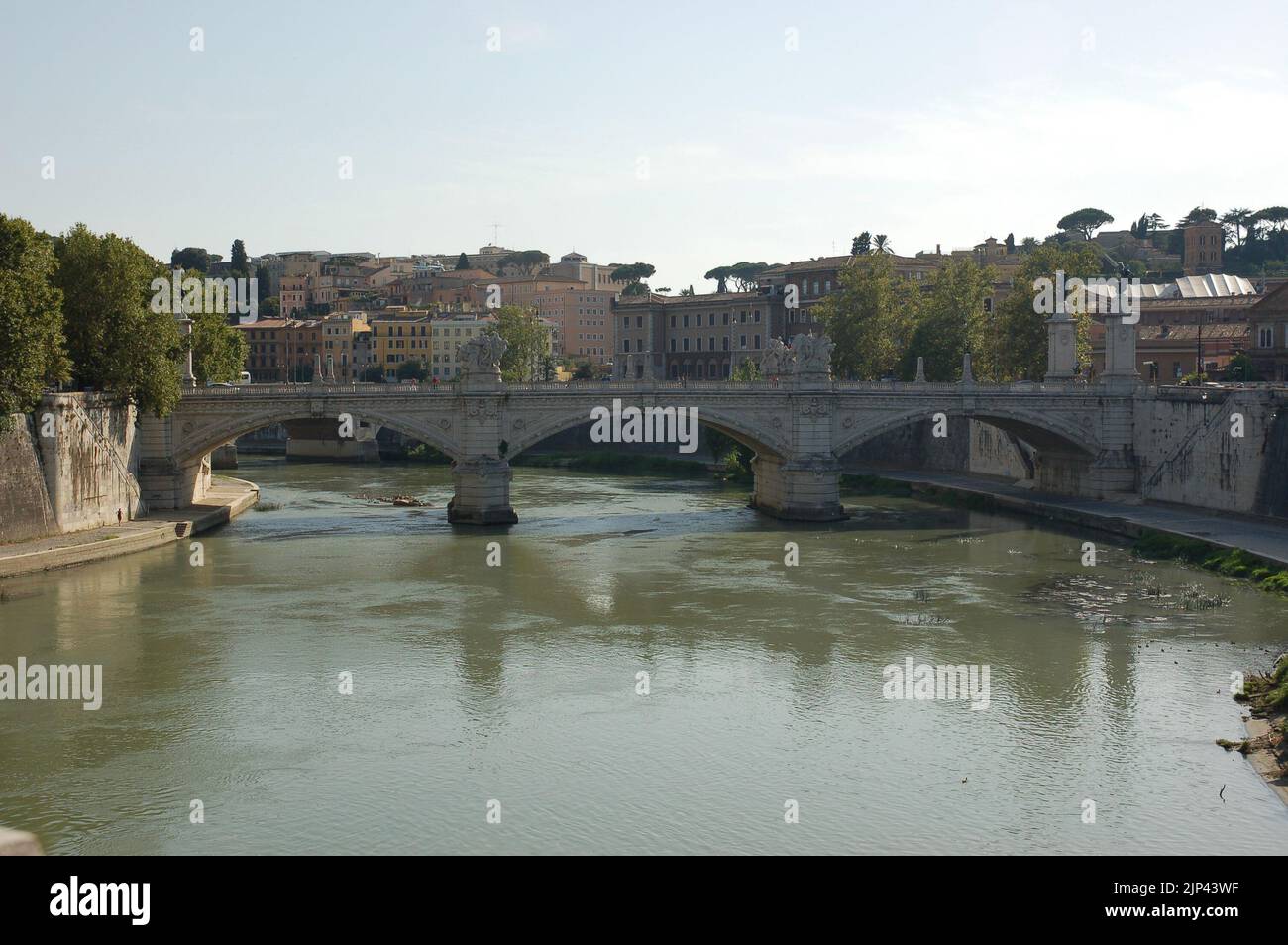 Der Tiber in Rom Italien mit der Brücke Ponte Vittorio Emanuele, die die Ufer und Wohngebäude im Hintergrund verbindet Stockfoto