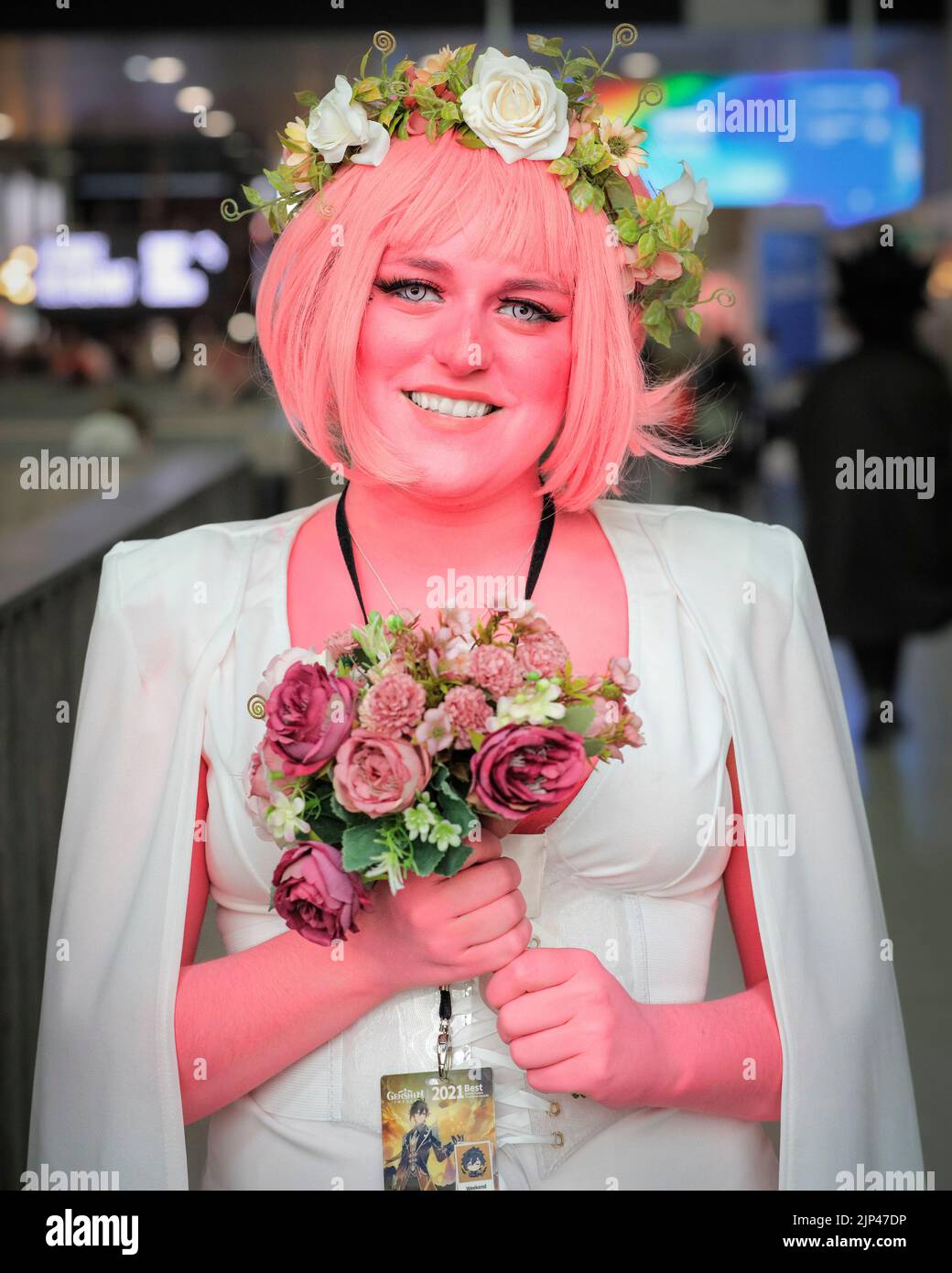 Persephone-Charakterkostüm aus dem Webcomic Lore Olympus, Cosplayerin posiert im Outfit mit rosa Haut und Haaren, MCM Comic Con London Stockfoto