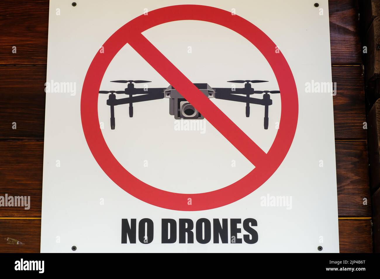 Warnzeichen des Verbots des Einsatzes von Drohnen im See-Naturschutzgebiet. Zeichen des Verbots von Video- und Fotoaufnahmen mit Drohnen, die in Nahaufnahme an einer Holzwand angebracht sind Stockfoto