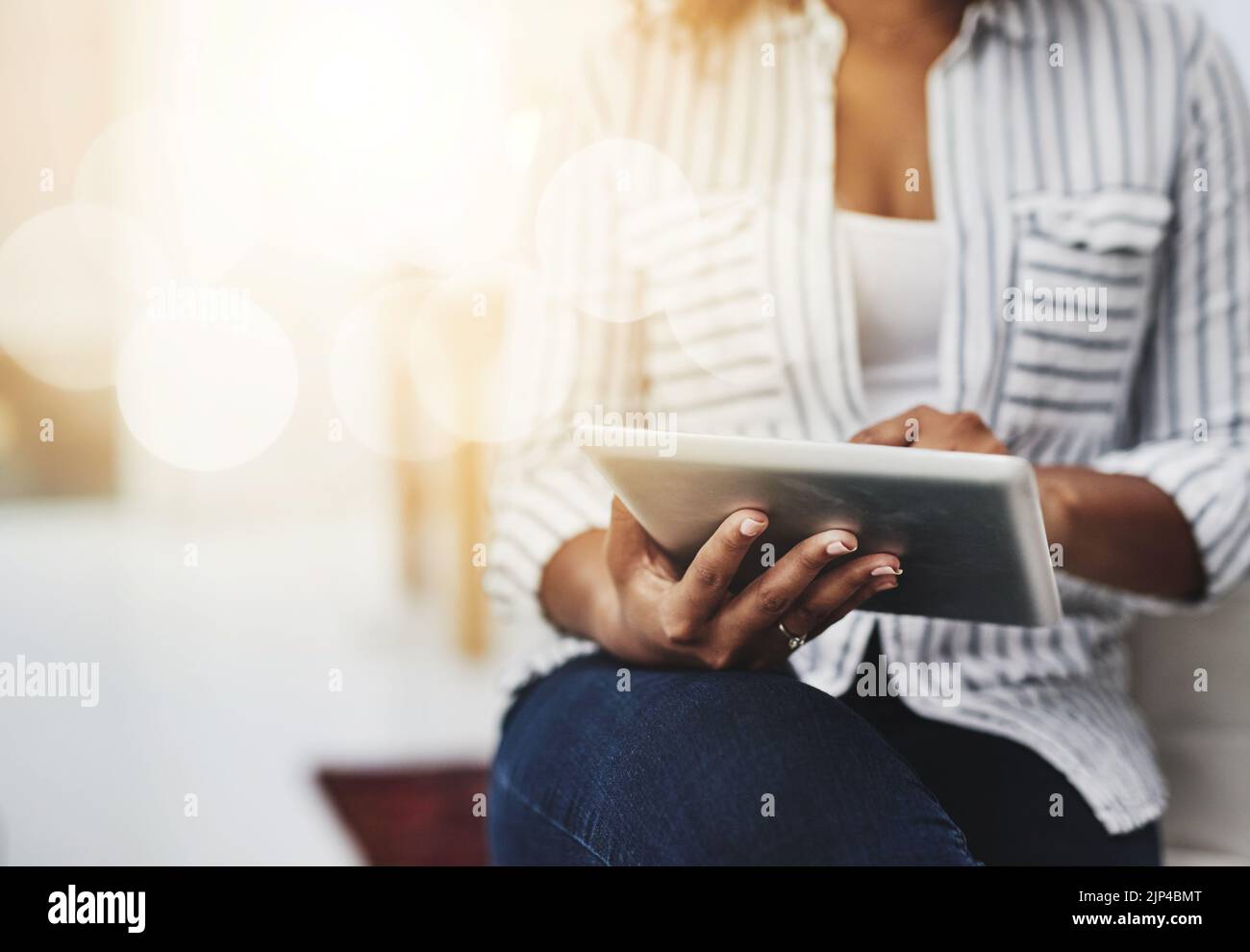 Tablet-Technologie in den Händen einer Frau, die in sozialen Medien surft, im Internet surft oder online chattet – mit Flare und Copyspace. Nahaufnahme eines Weibchens Stockfoto