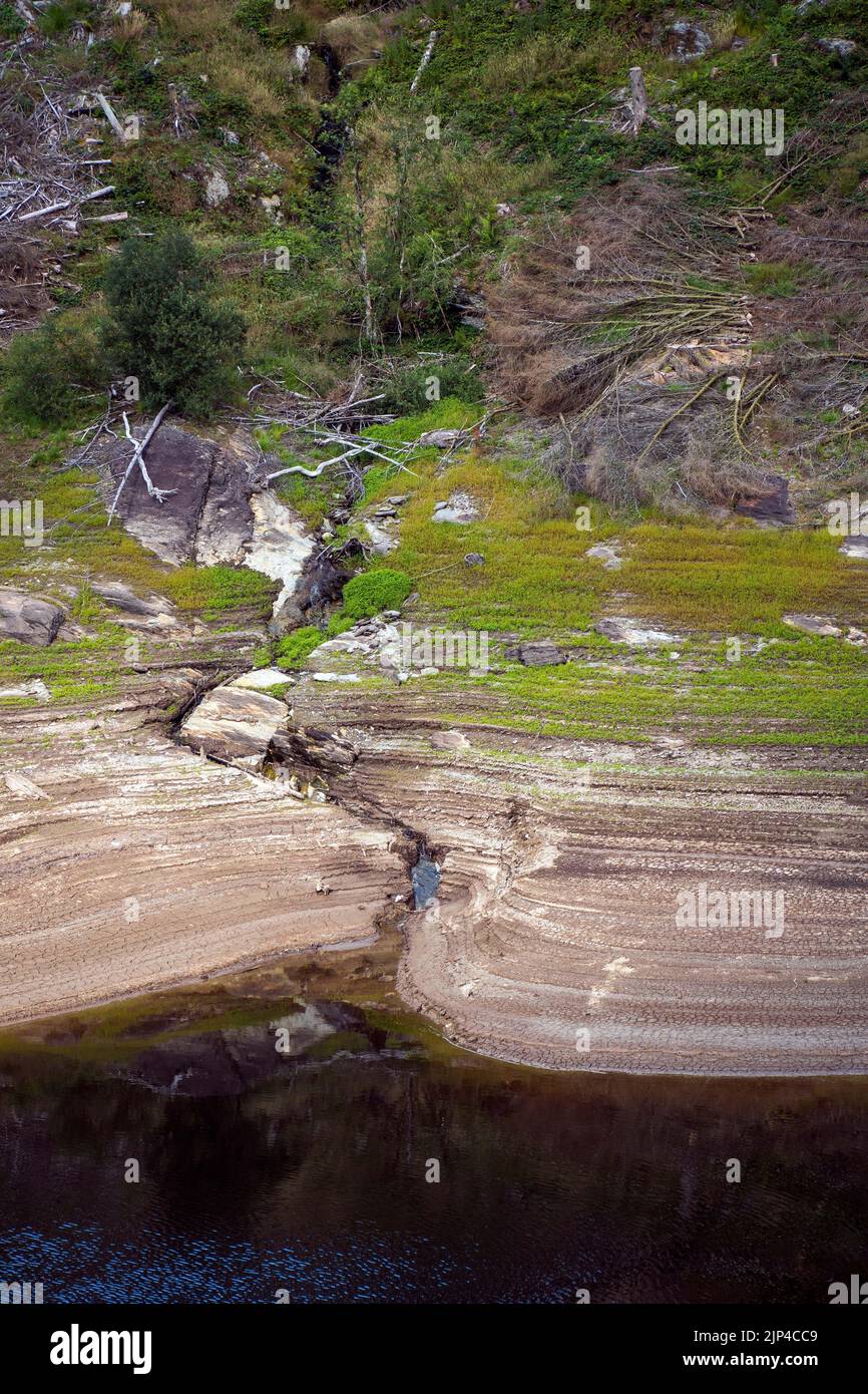 Aufgrund fehlender Niederschläge sind die Konzentrationen im Llyn Brianne Reservoir gesunken. Der niedrige Wasserstand ist aus dem neu exponierten Land ersichtlich. Stockfoto