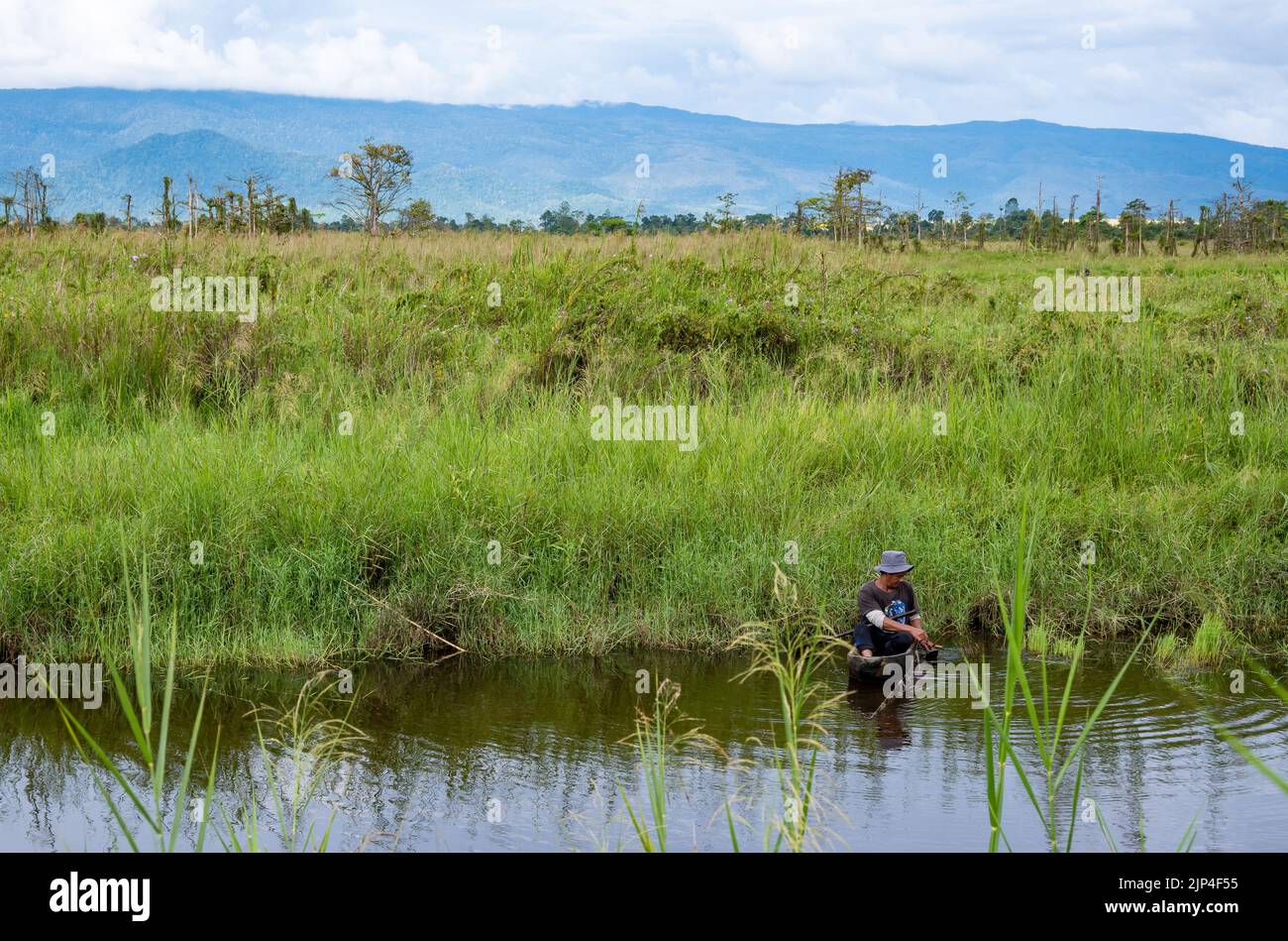 Ein einheimischer Mann in einem Eindugout-Kanu, der in einem See angeln kann. Sulawesi, Indonesien. Stockfoto