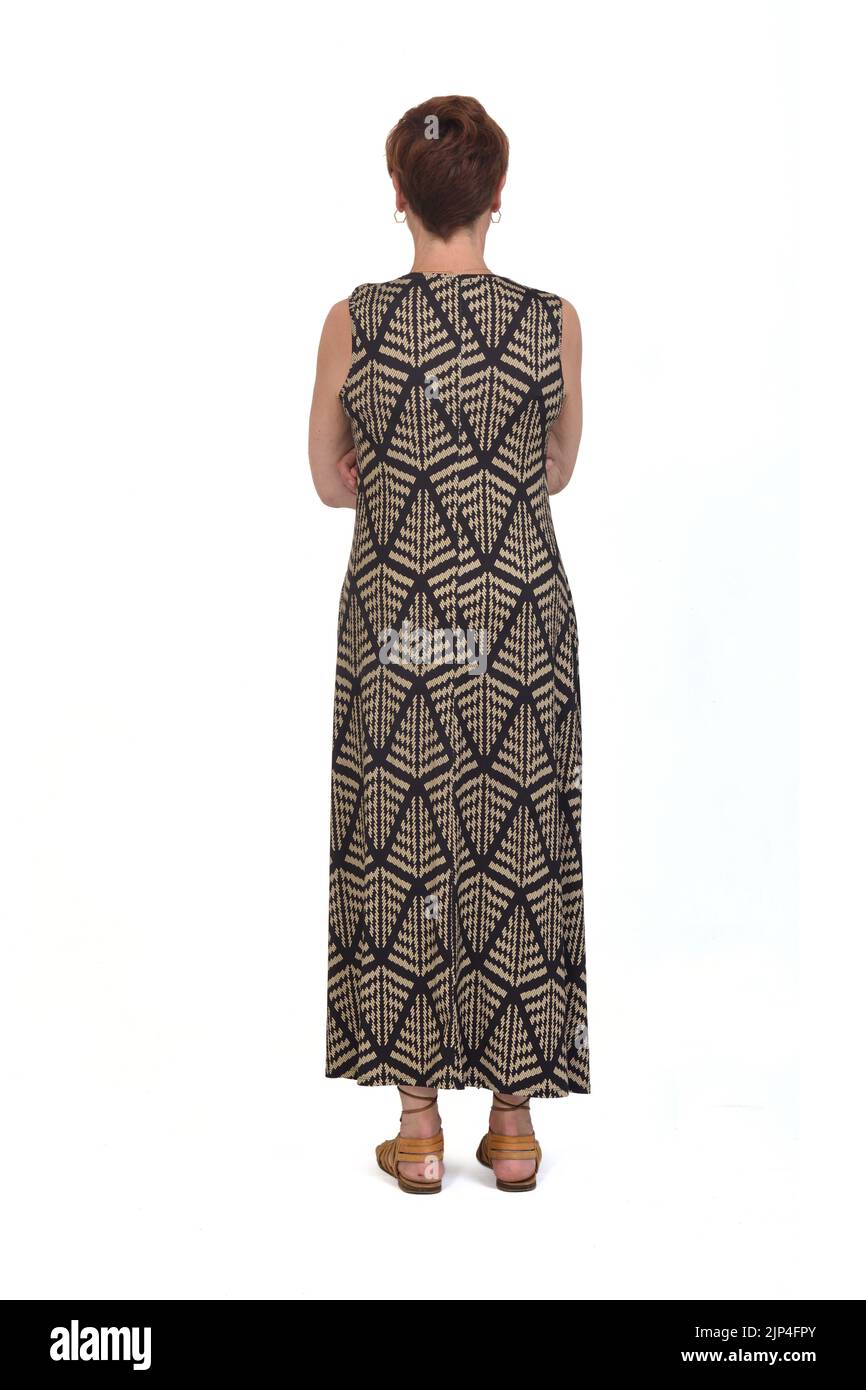 Volle Rückansicht einer Frau mittleren Alters in einem Kleid, gekreuzt armd auf weißem Hintergrund Stockfoto