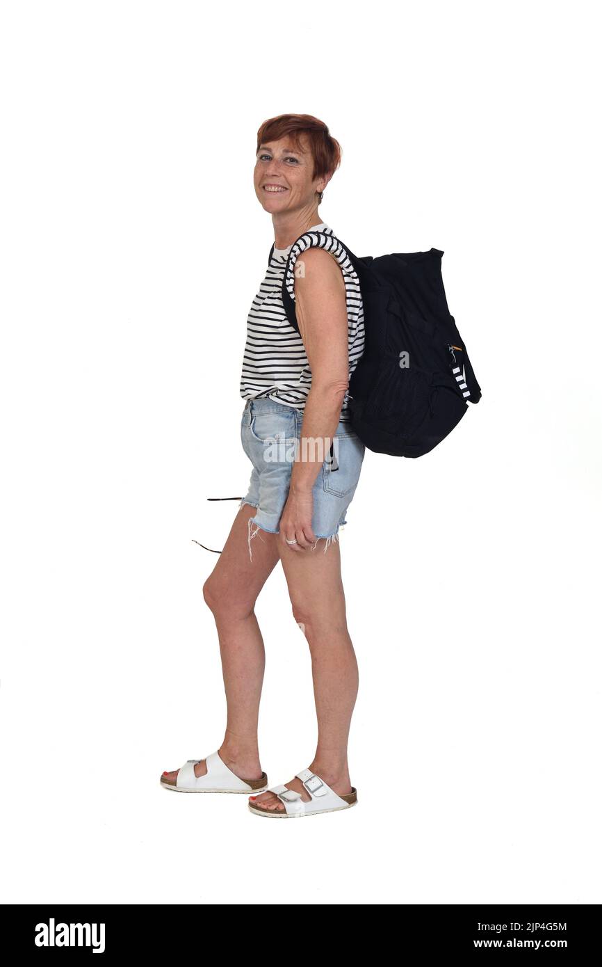 Seitenansicht einer Frau mittleren Alters an einem Sommertag mit Rucksack Blick auf Kamerra auf weißem Hintergrund Stockfoto