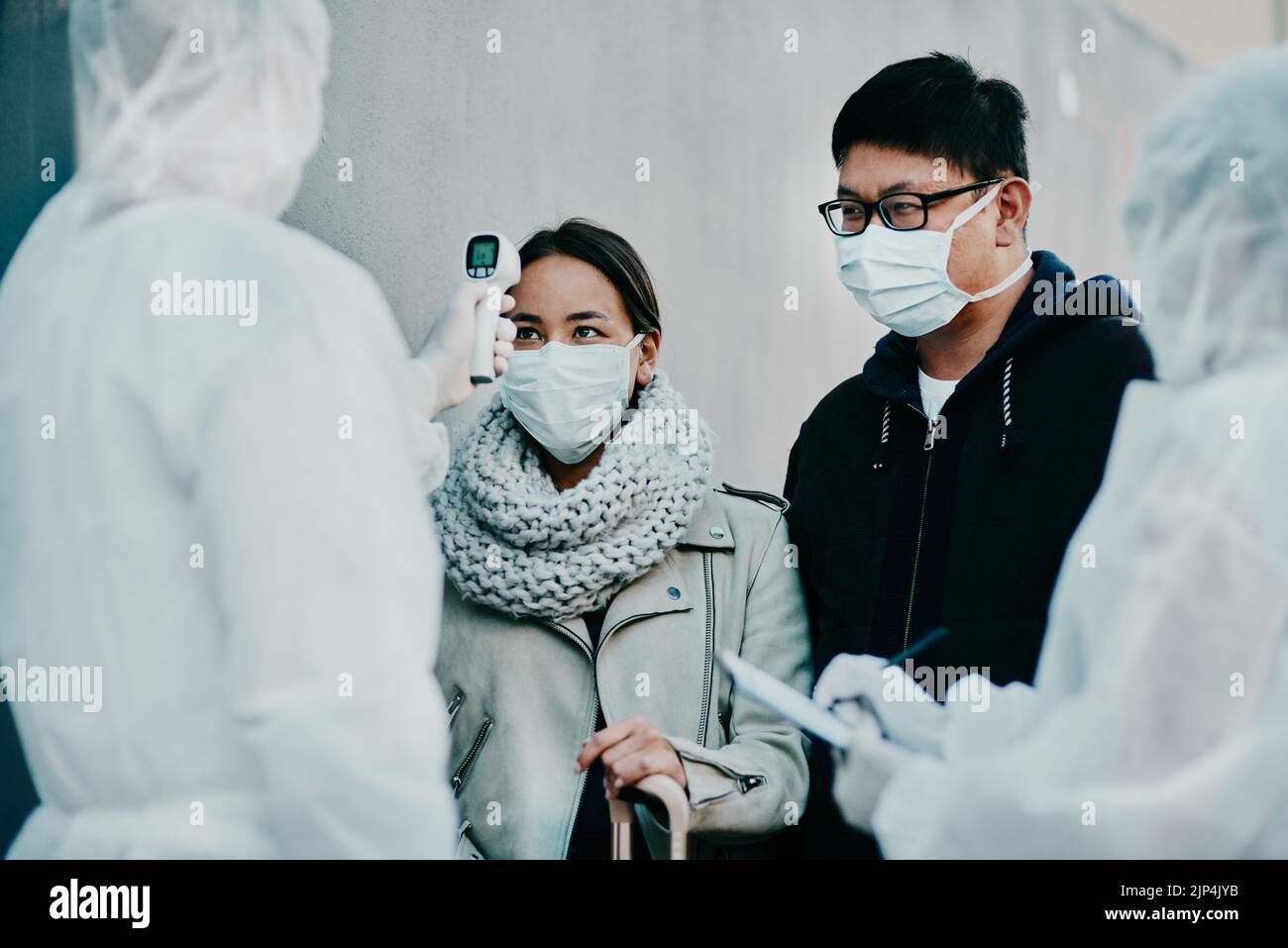 Das Reisende Paar erhält einen kovidierten Temperaturscan an an der Grenze zur medizinischen Sicherheit, der während einer Pandemie einen Screening-Test auf Sicherheit macht. Ausländische Menschen Stockfoto