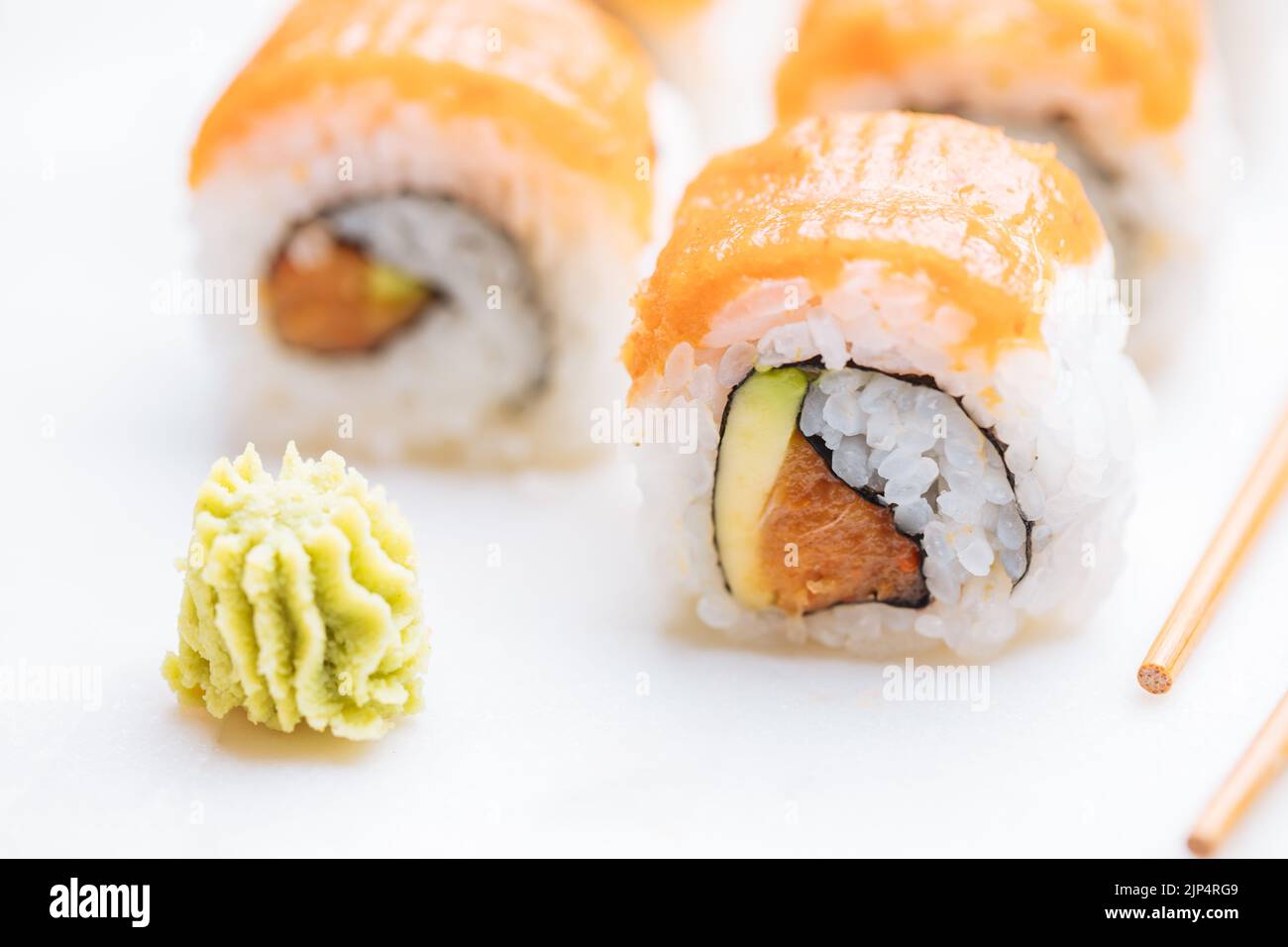 Sushi-Rollen auf Platte, heller Hintergrund. Serviert mit Wasabi und Ingwer. Verschiedene japanische Sushi. Traditionelles Essen. Stockfoto