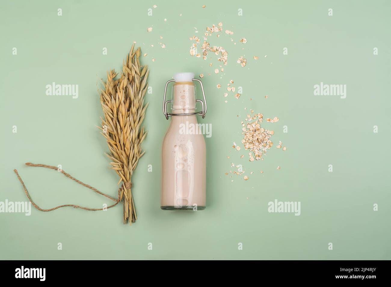 Laktosefreie Milch auf pflanzlicher Basis. Hausgemachte Hafermilch mit Zutaten auf Holzgrund. Welttag der Pflanzenmilch. Speicherplatz kopieren Stockfoto