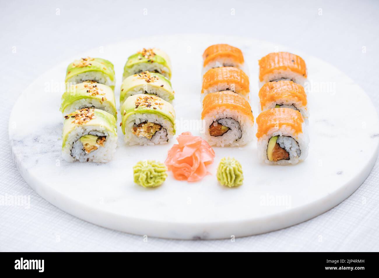 Sushi-Rollen auf Platte, heller Hintergrund. Serviert mit Wasabi und Ingwer. Verschiedene japanische Sushi. Traditionelles Essen. Stockfoto