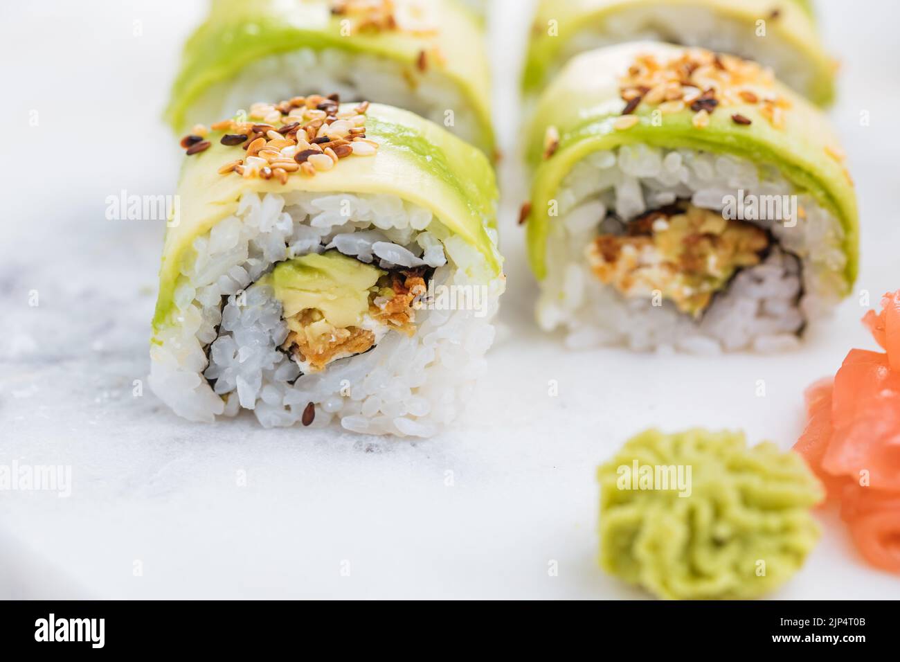 Sushi-Rollen auf Platte, heller Hintergrund. Serviert mit Wasabi und Ingwer. Verschiedene japanische Sushi. Traditionelles Essen. Stockfoto
