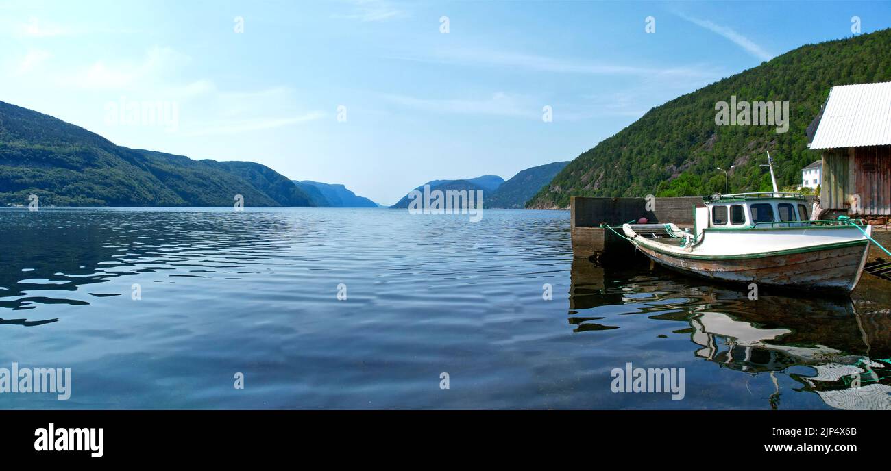 Boot an der Küste durch ein Haus in einem Fjord, Nordeuropa gebunden Stockfoto