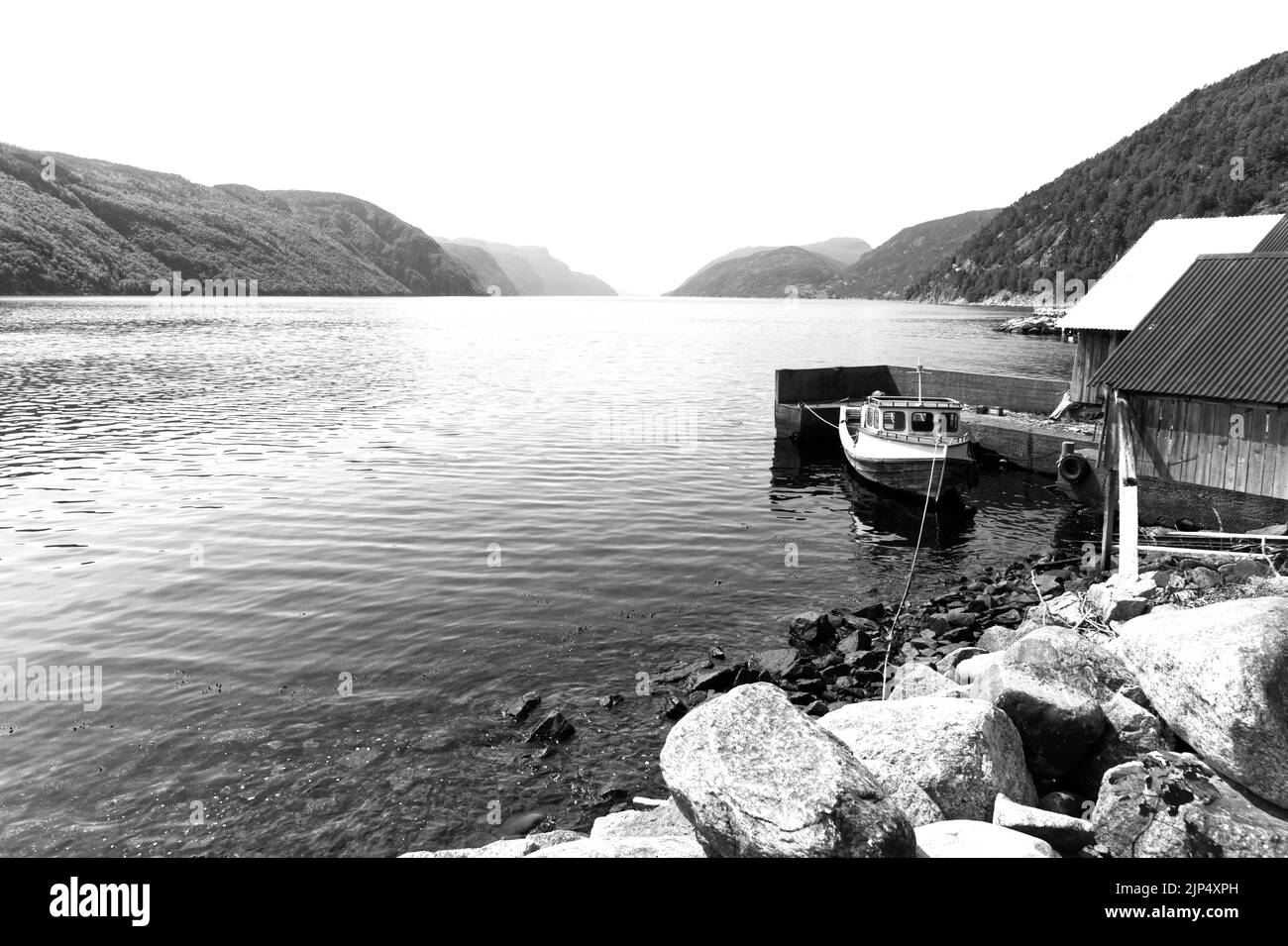 Boot an der Küste durch ein Haus in einem Fjord, Nordeuropa gebunden Stockfoto