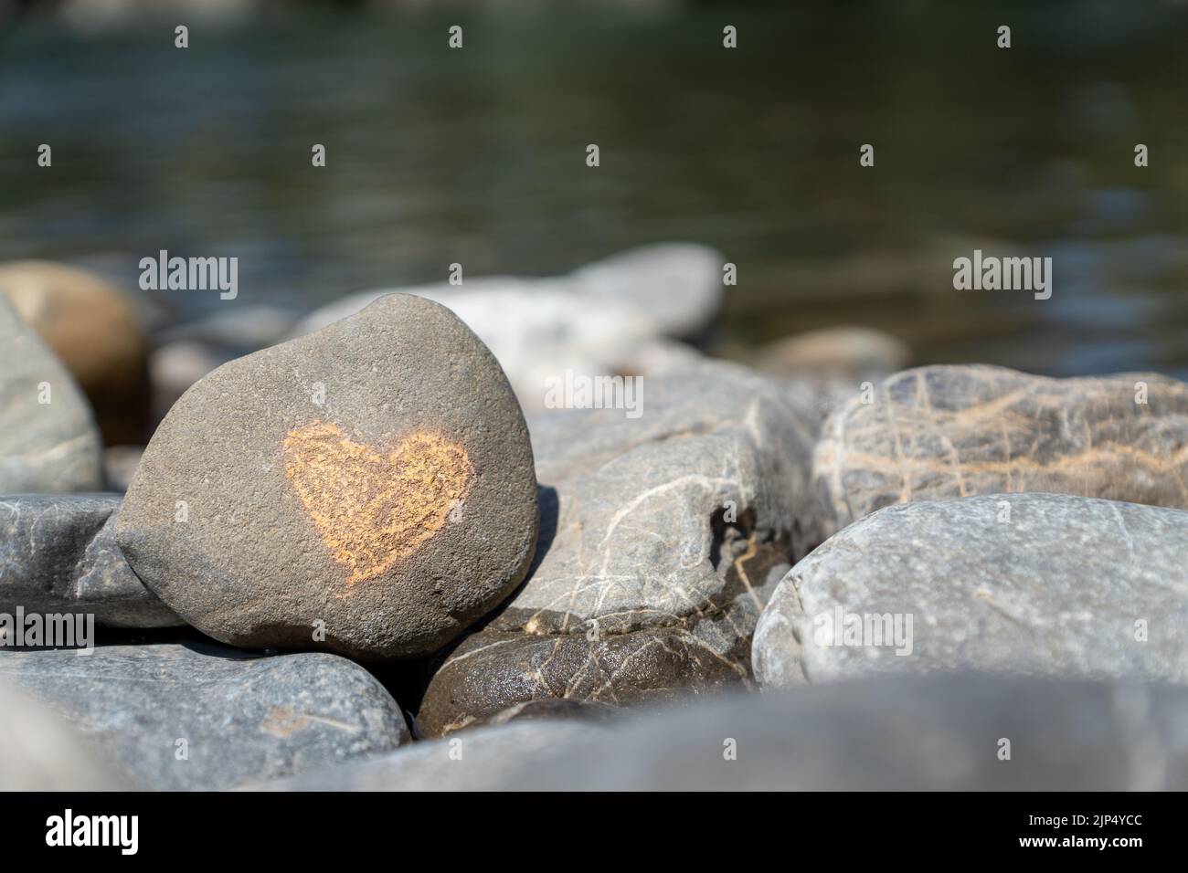 Ein kleines Herz auf hartem Stein Stockfoto