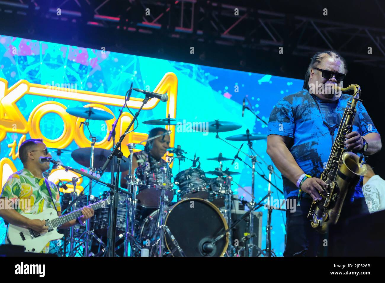 (L-R) Rick Marcel Gitarrist, George 'Funky' Brown Drummer, Louis Van Taylor Saxophonist mit der amerikanischen Funk-Soul- und Disco-Band Kool and The Gang, treten beim Boomtown Fair Festival live auf. Boomtown ist ein britisches Musikfestival, das jedes Jahr auf dem Matterley Estate im South Downs National Park in der Nähe von Winchester stattfindet. Kool & The Gang ist eine amerikanische R&B/Soul/Funk-Band, die 1964 in Jersey City, New Jersey, von den Brüdern Robert 'Kool' Bell und Ronald Bell mit Dennis 'Dee Tee' Thomas, Robert 'Spike' Mickens, Charles Smith, George Brown und Ricky West gegründet wurde. Sie haben zahlreiche Veränderungen erfahren Stockfoto