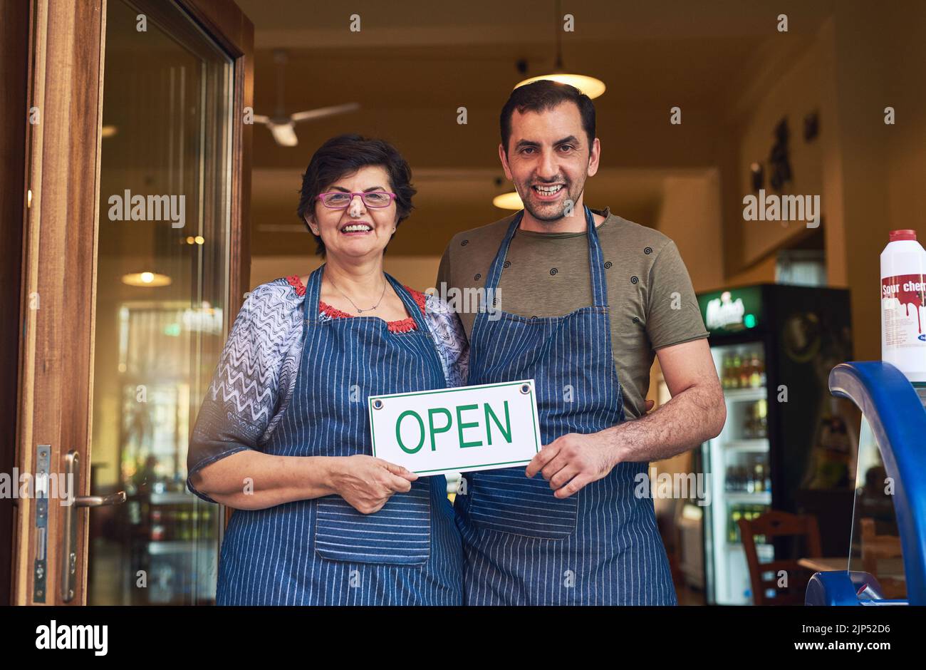 Nun, seien Sie jeden Tag für viele weitere Generationen geöffnet. Beschnittenes Porträt einer reifen Frau und ihres erwachsenen Sohnes, die am Eingang zu ihrem Familieneis stehen Stockfoto