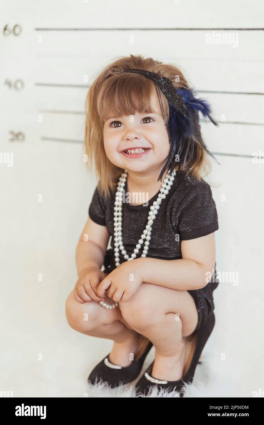 Charmantes Baby in Gangsterkostüm auf der Polizeistation Stockfoto